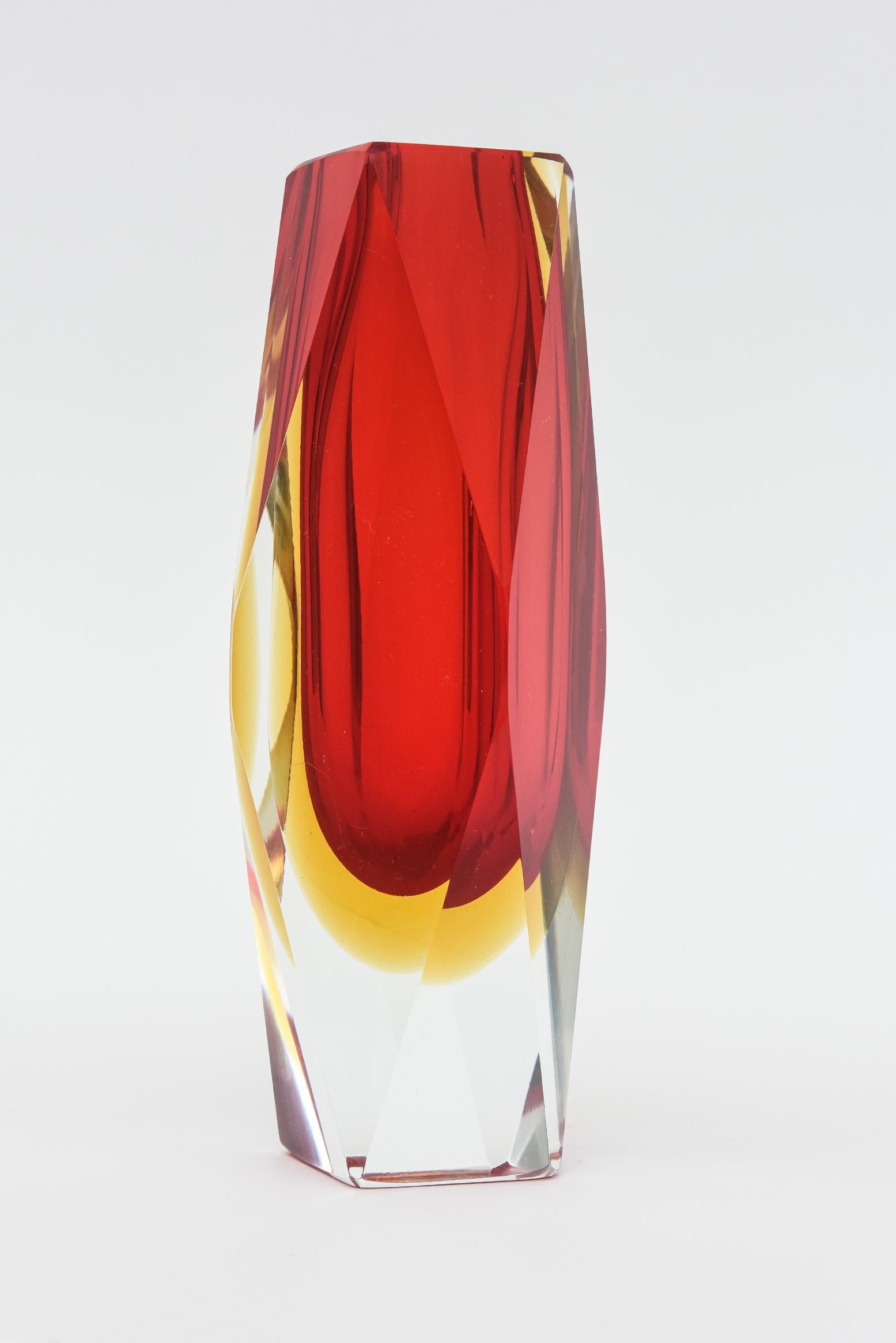 Ce magnifique vase vintage en verre de Murano, réalisé par Alessandro Mandruzzato, présente la stratification Sommerso de verre facetté rouge et jaune avec une base transparente. Italien, soufflé à la main et datant des années 70. Ce sont des