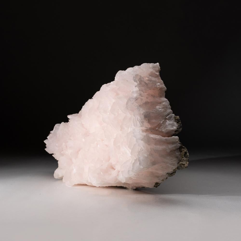 From Chenzhou Prefecture, Hunan Province, China

Translucent pale-pink crystals of sharp flattened rhombohedral manganoan calcite in parallel formation. The calcite crystals have lustrous crystal faces with pale-pink color due to manganese-rich