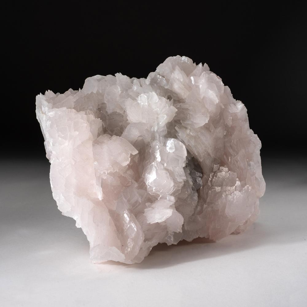 De la préfecture de Chenzhou, province de Hunan, Chine Cristaux translucides rose pâle de calcite manganoïde rhomboédrique aplatie en formation parallèle. Les cristaux de calcite ont des faces cristallines lustrées de couleur rose pâle en raison des