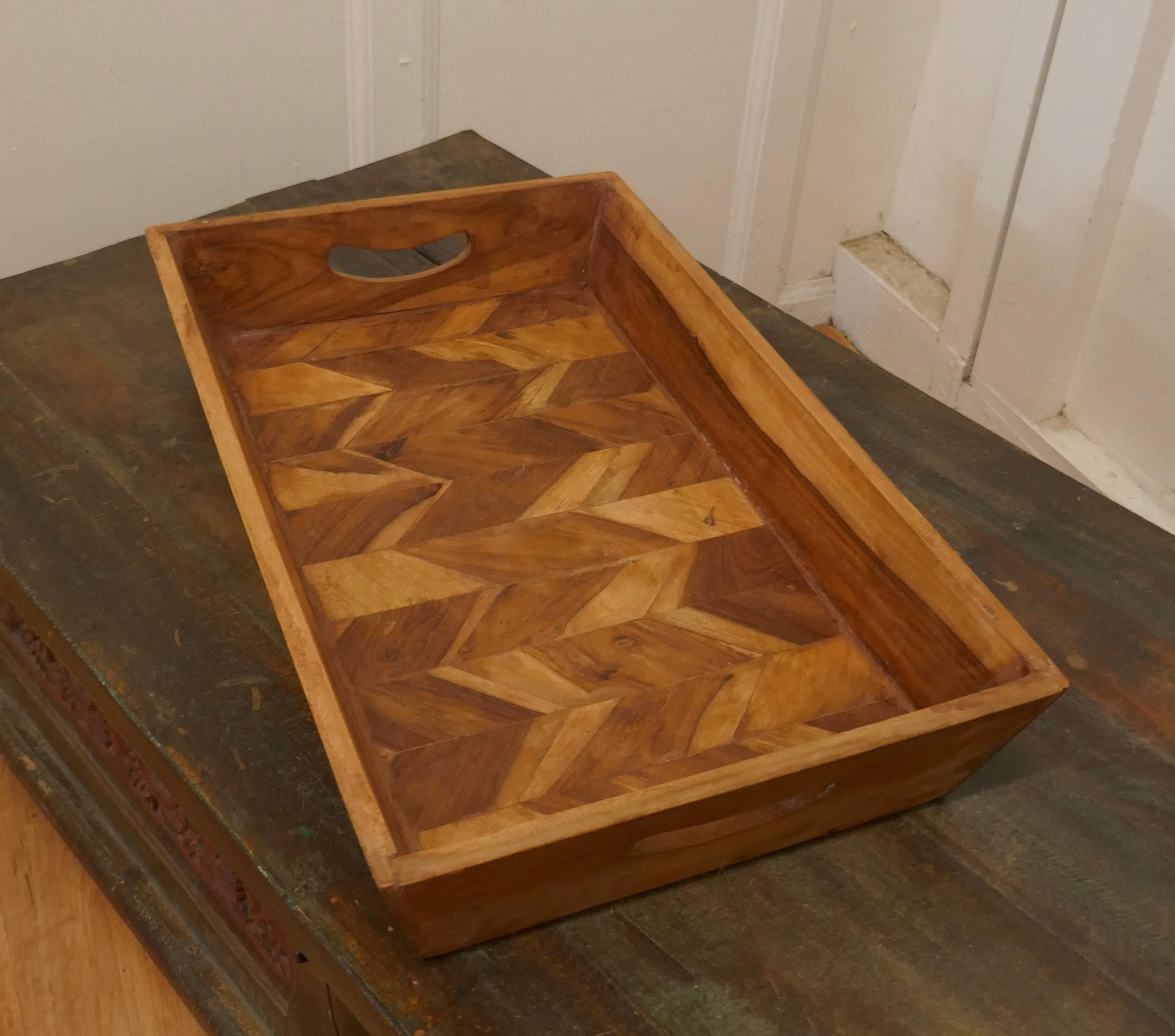 Mango wood Indian artisan country tray.

A good honest piece, the tray is made in a marquetry of Mango Wood, it has a raised gallery and inset carrying handles
A great piece in good condition.
The tray is 4” high, 21” long and 13” across.
TAC171