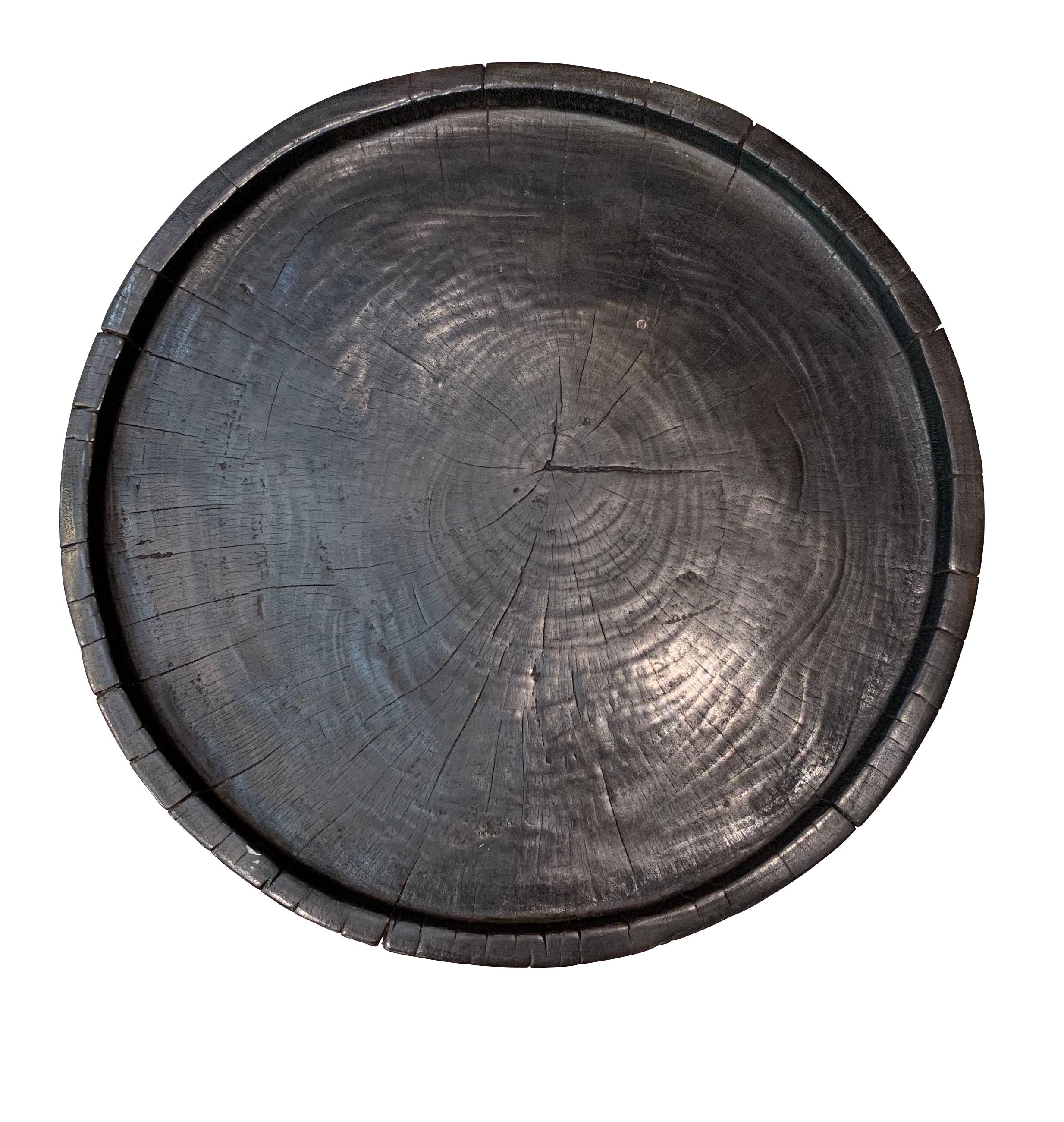 This Indonesian round side table is made of mango wood with an ebonized finish.
Four vertical side bands decorate the sides.
There is a slight lip around the flat top.
The mango wood makes for a very sturdy table.
 
