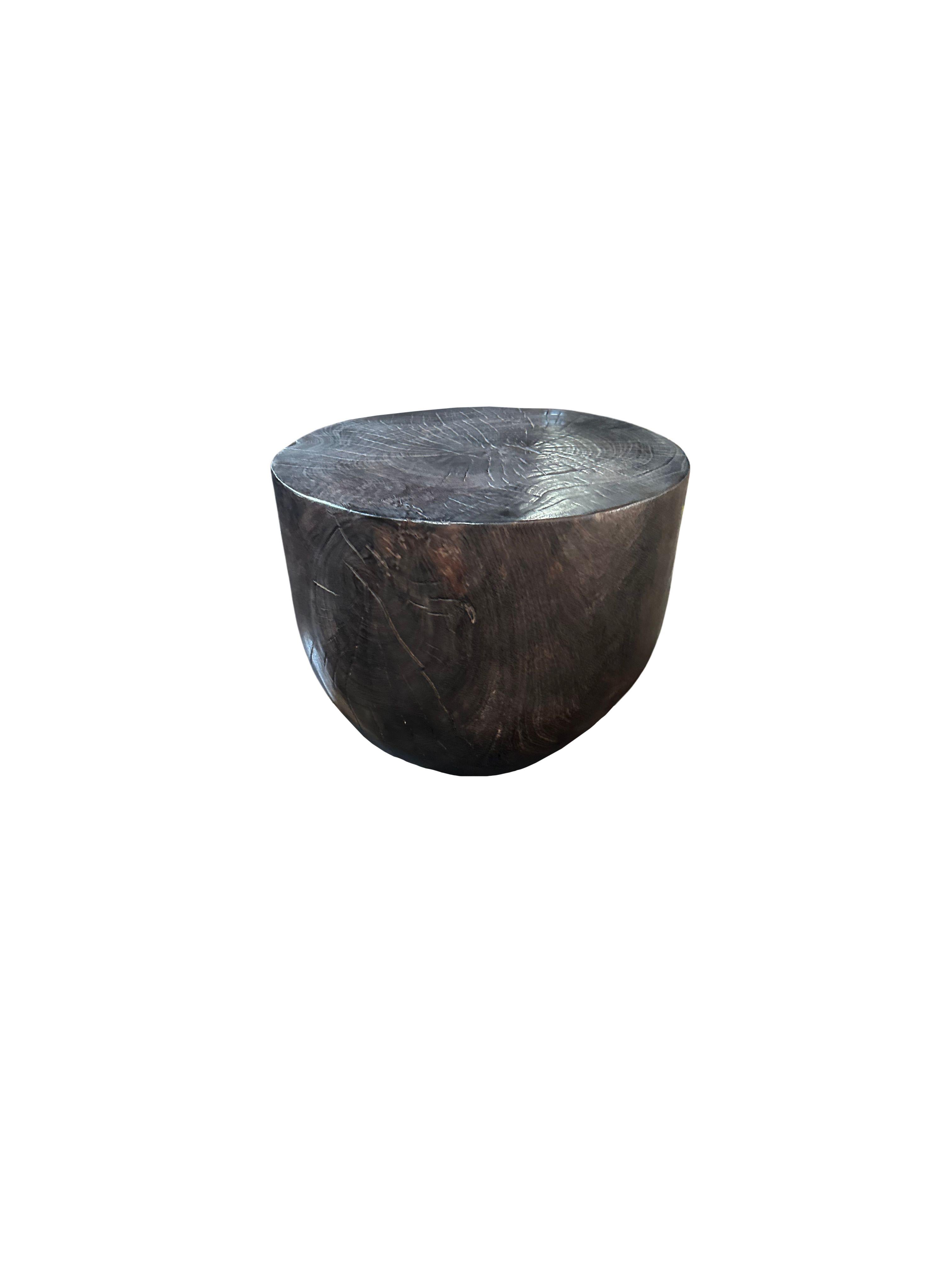 A sculptural side table crafted from solid mango wood. To achieve its dark pigment the wood was burnt several times and finished with a clear coat. The wood textures and shades present on all sides adds to its charm. 1400