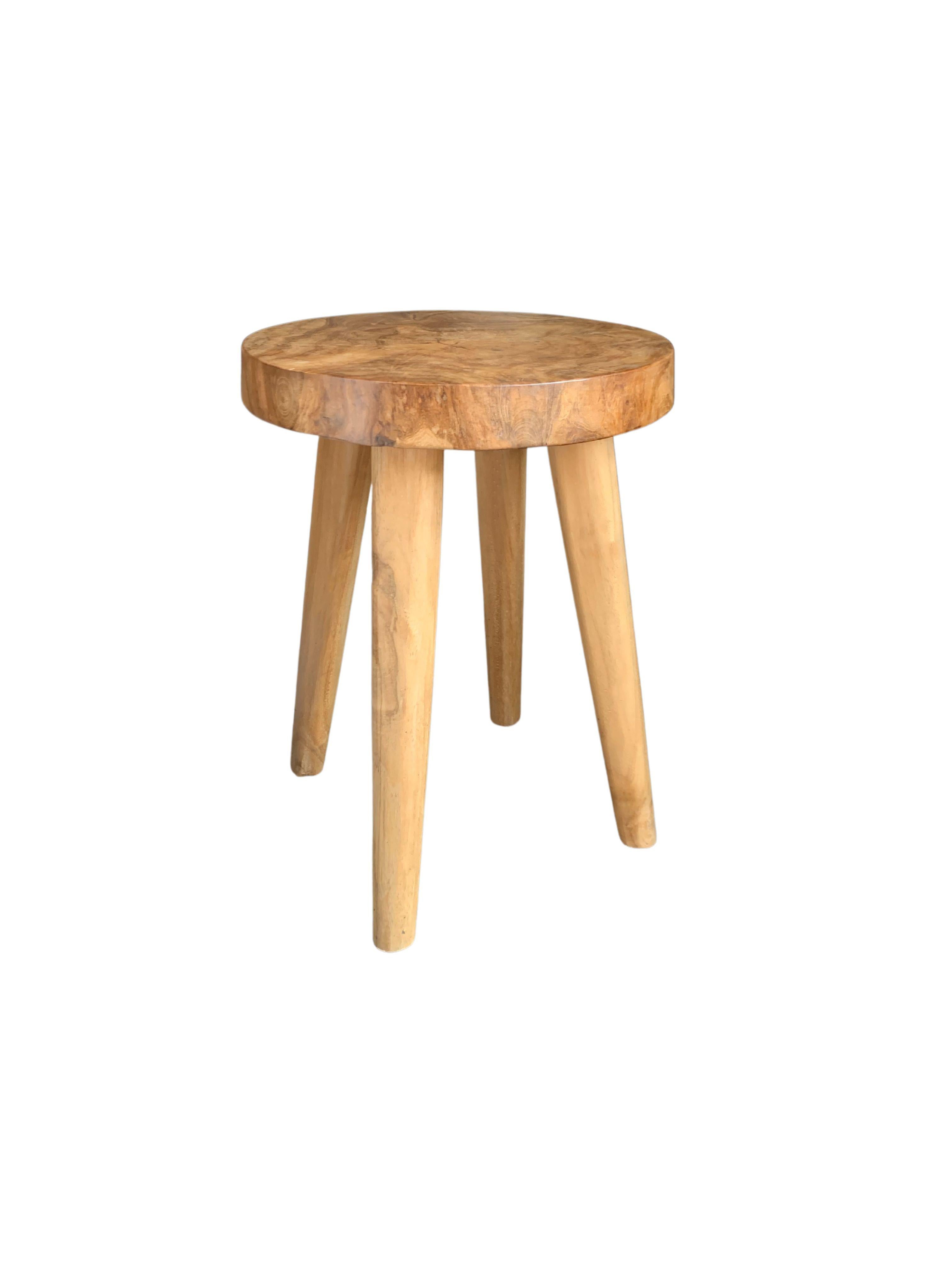 This wonderfully sculptural stool was crafted using mango wood. The chair sits on 4 slender legs. Its neutral pigment makes it perfect for any space. A uniquely sculptural and versatile piece certain to invoke conversation. This chair features a