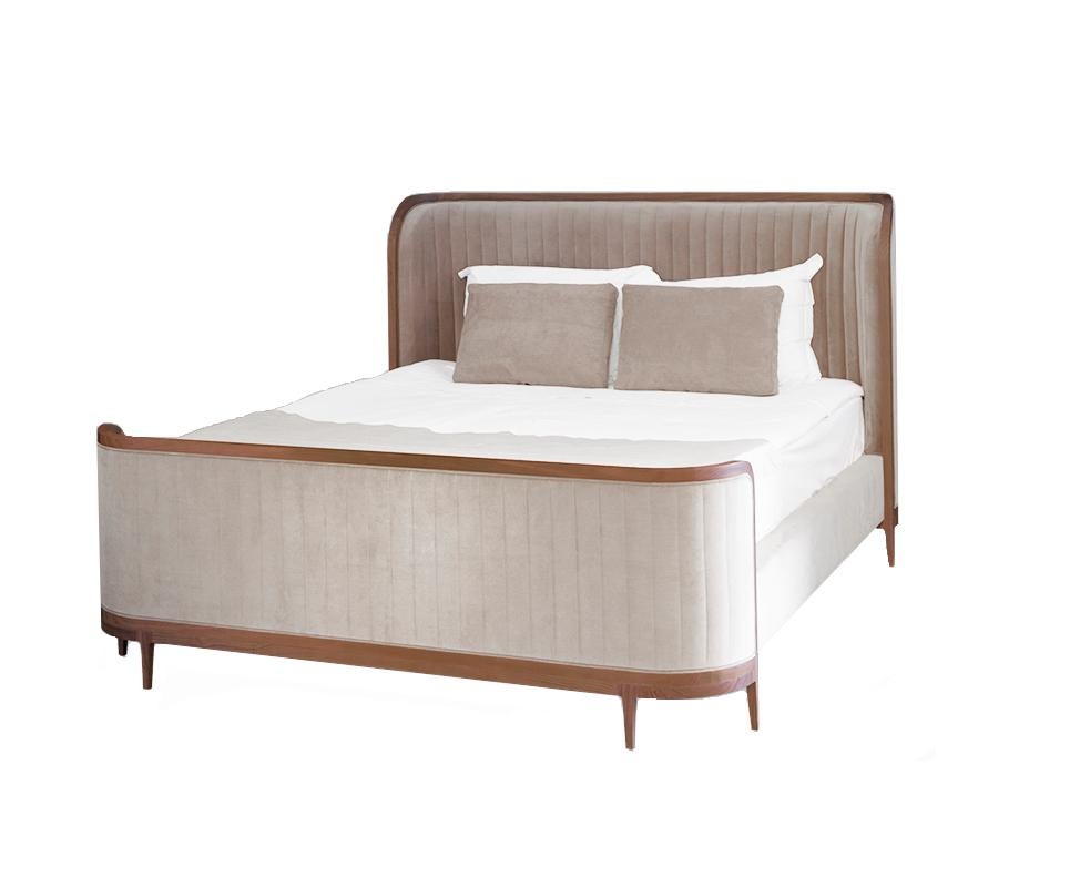 Soft, sweeping curves and a channel tufted head and footboard are elegantly framed in wood for a chic uptown look.