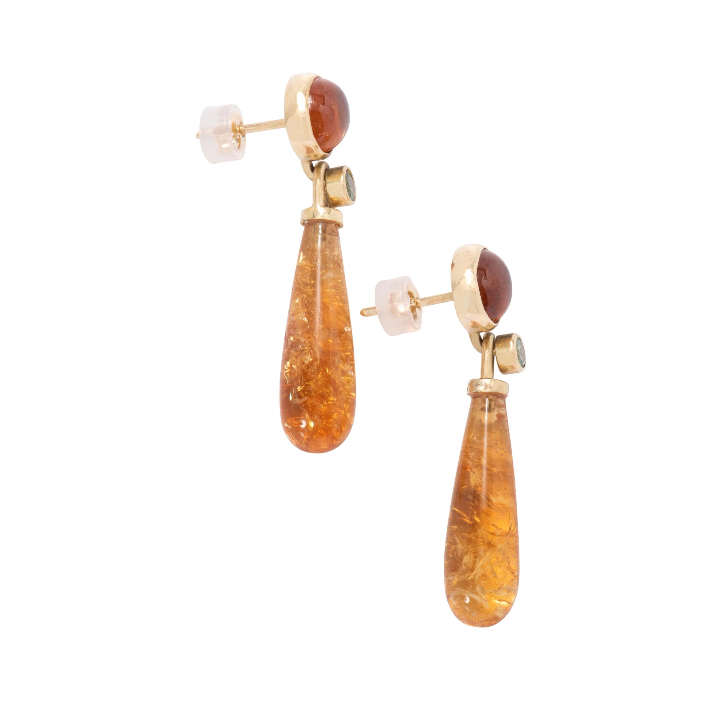 Fiery, cool Manhattan Citrine Drop Earrings in 18 karat gold like a whiskey on the rocks gleam with the promise of an unforgettable night on the town. 22.88 carats of citrine wands are topped with twinkling green garnets .43ctw and hang from glowing