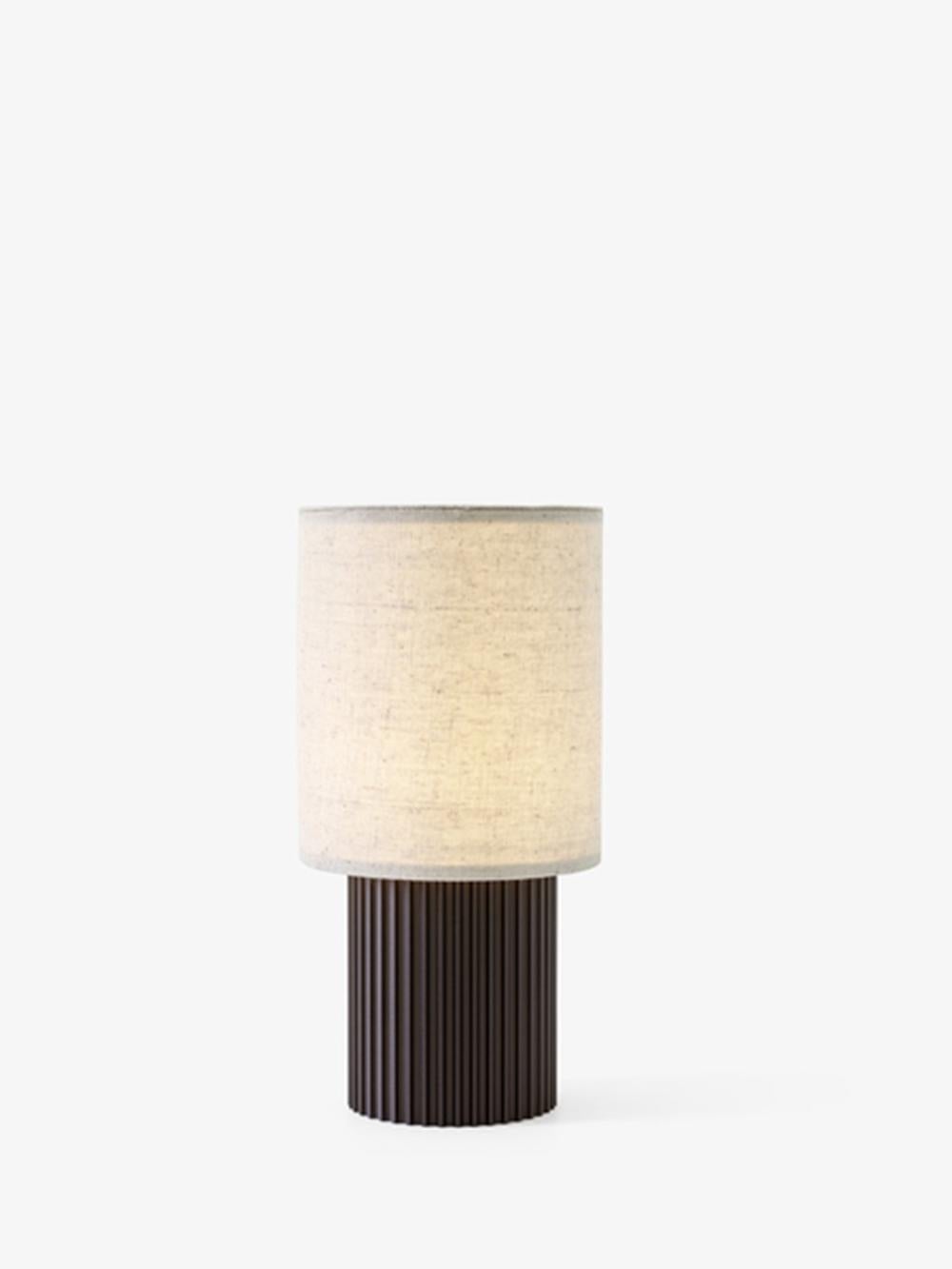 Ensure the ambiance is right with Manhattan SC52, a portable table lamp from Space Copenhagen. 
Its industrial-inspired base is made from anodized aluminium with a columned detailing; a cream-coloured canvas shade sits atop. 
This battery-powered