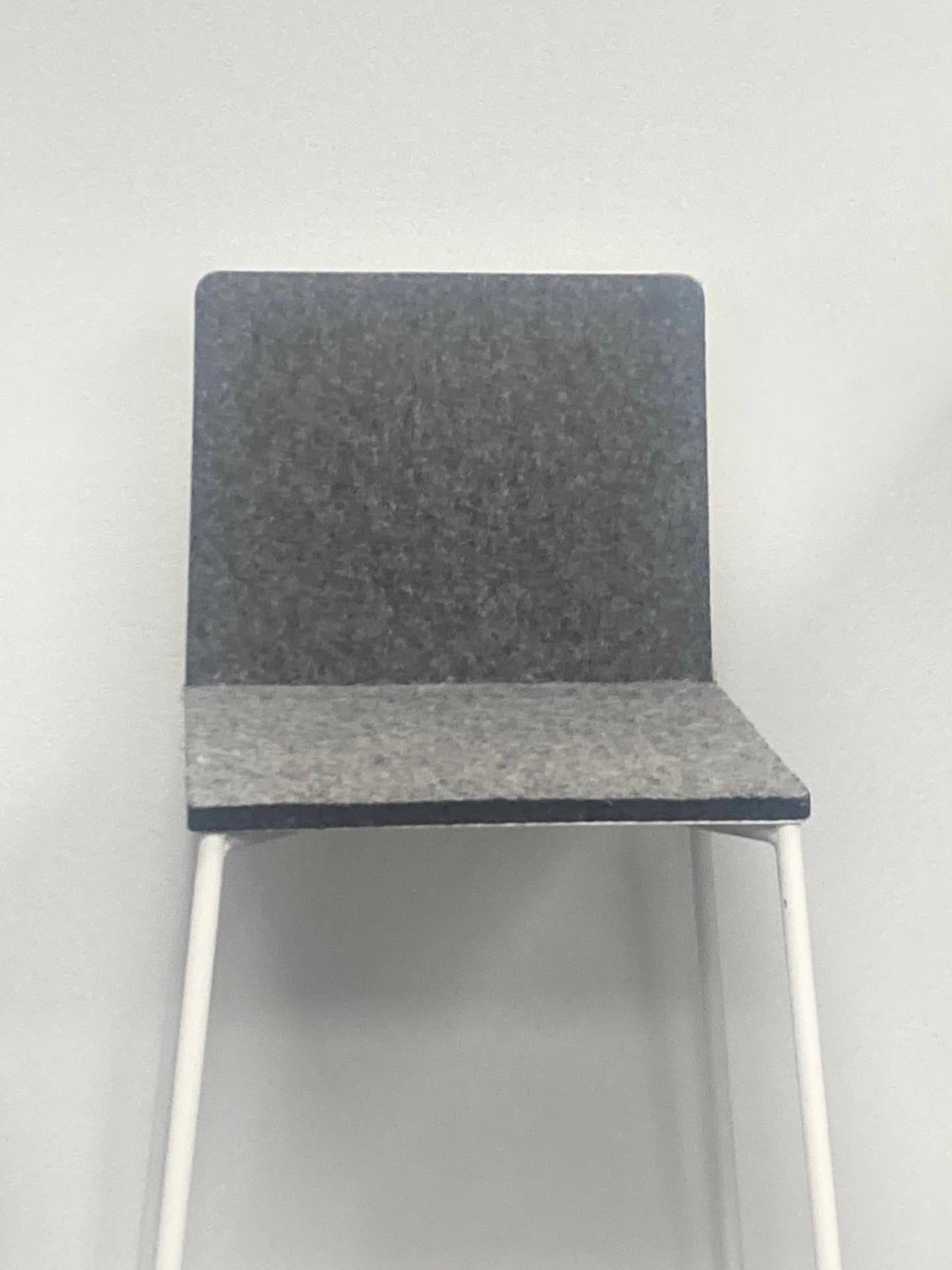 The MANHATTAN barstool was designed by Maurizio Peregalli for the Italian brand ZEUS, known for its industrial and natural aesthetic. It features a thin frame made from sandblasted stainless steel and painted pure white with a seat and backrest