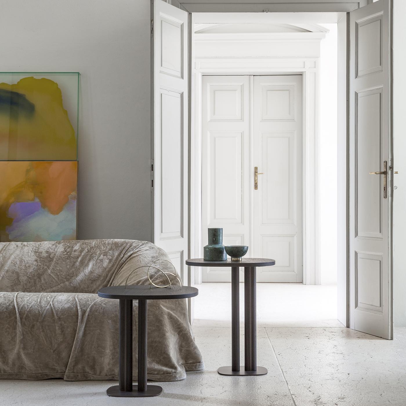 Manhattan situated between two rivers inspired the dynamic design of this side table, where a burnished metal base varnished with epoxy powders is flanked by solid oak inserts. Its shaped MDF top (19 mm thick) is veneered with Laguna oak that stays