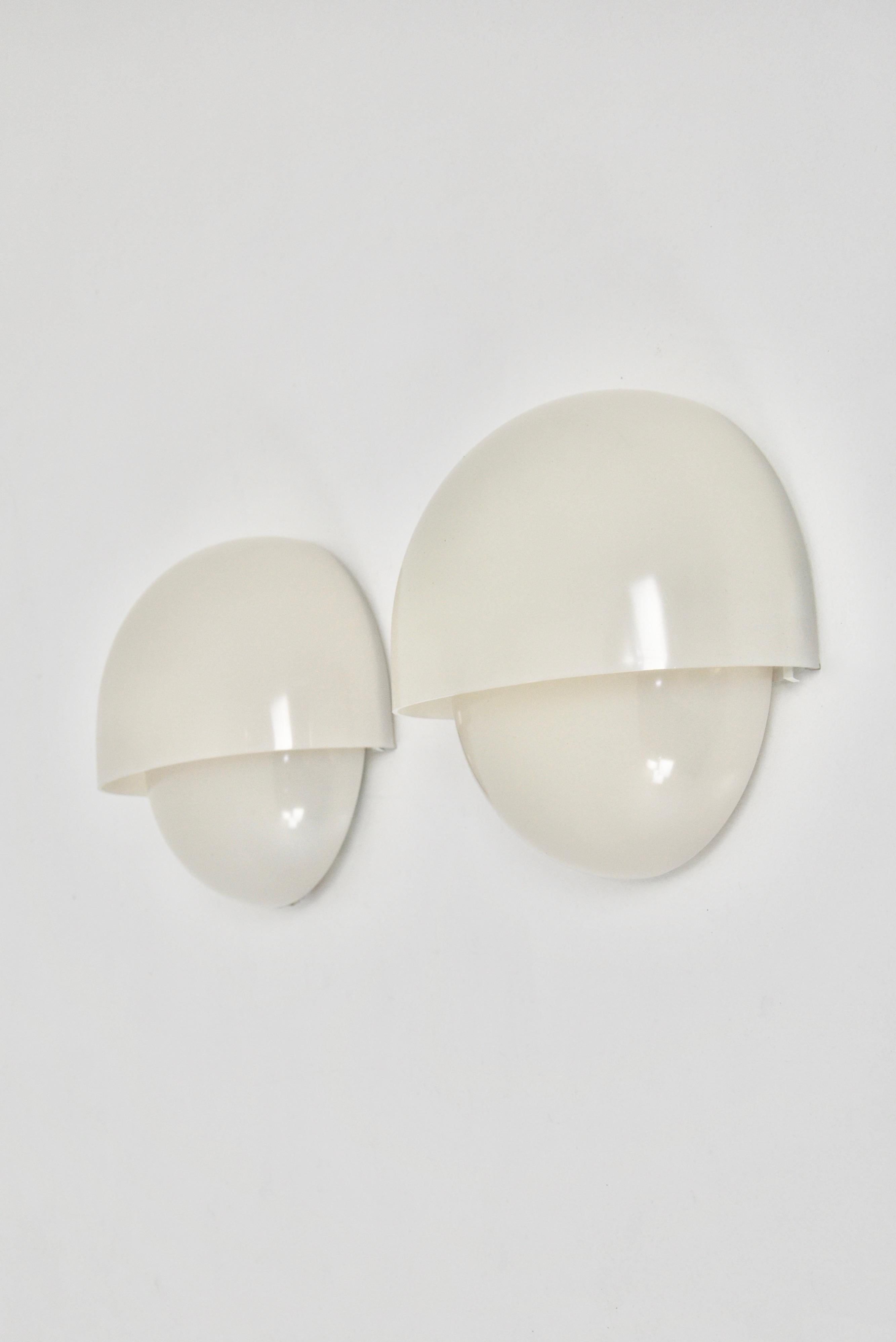 Pair of white wall lamps in plastic and metal by Vico Magistretti. Wear due to age and time.