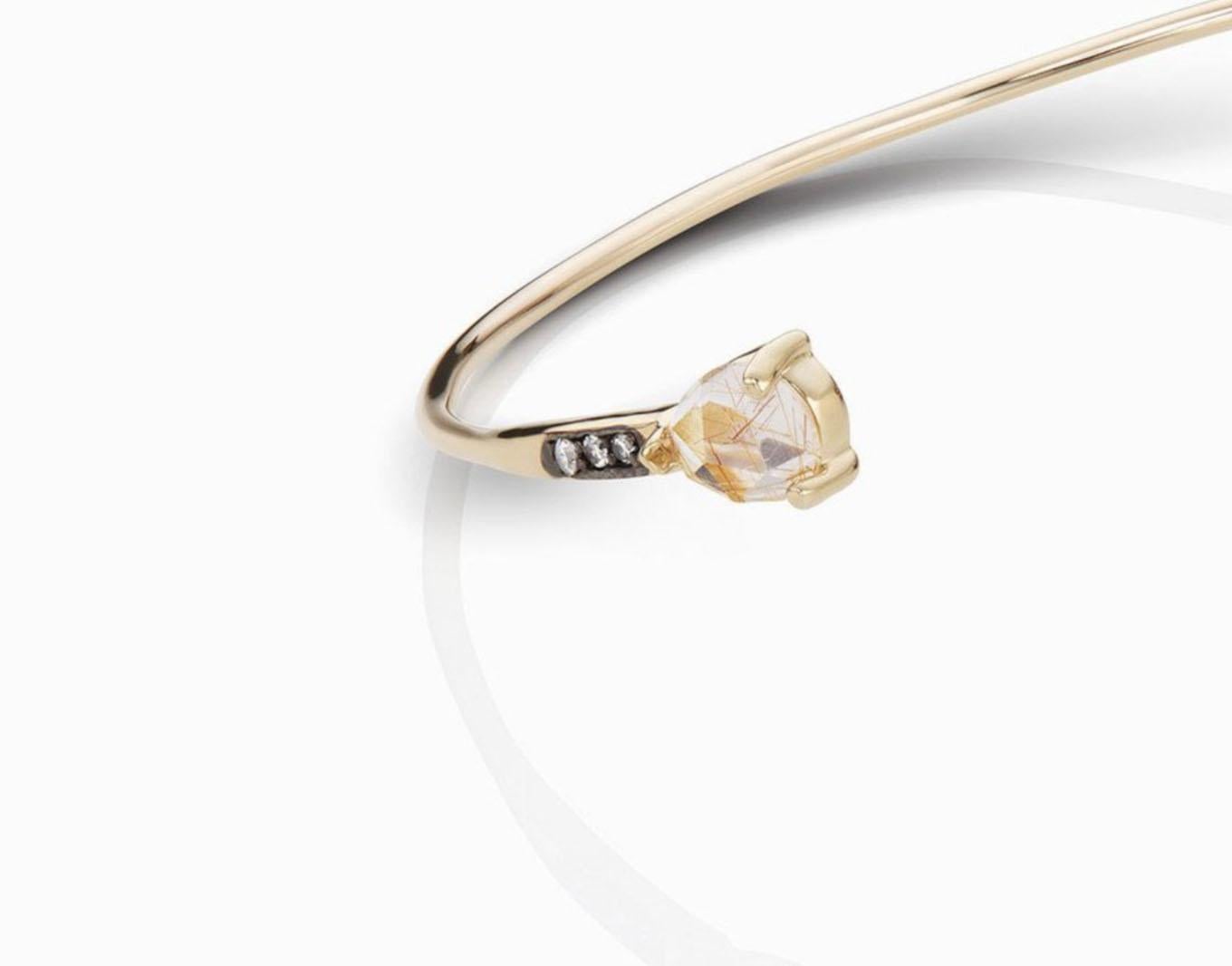 MANIAMANIA Mystic fine bangle in 14k yellow gold, with 7x5mm custom rose cut Rutilated Quartz, 4mm rose cut round Champagne Diamond, with white diamond pave detail.

This delicate gold bangle was hand made in NYC. Inspired by the Victorian era, this