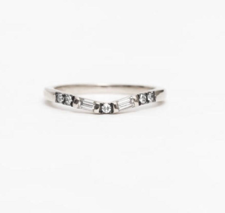 MANIAMANIA Vega Wedding band in 14k White Gold, slightly curved band featuring two white baguette cut diamonds (0.15 ctw), and pavé of white diamonds (0.075). Size 6

The Vega band is hand made in NYC, and is a unique wedding band designed to pair