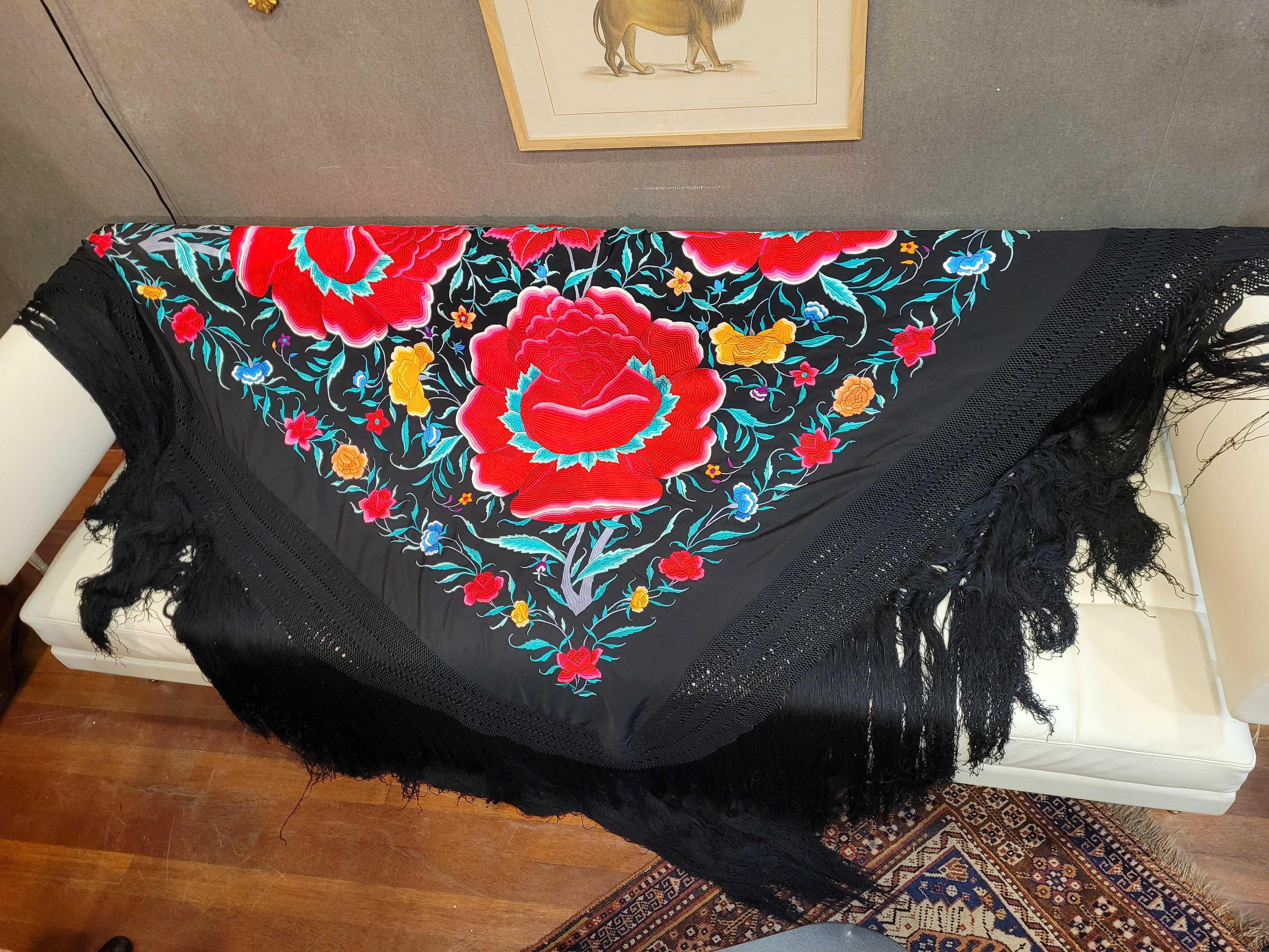 Outstanding antique Manila shawl made of black silk with embroidery in a wide variety of colors. As is usual in this type of piece, the base fabric is silk and the threads with which the ornaments are embroidered are also silk.

The technique used