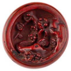 Manj netsuke in red lacquer, carved and decorated with red and black lacquer