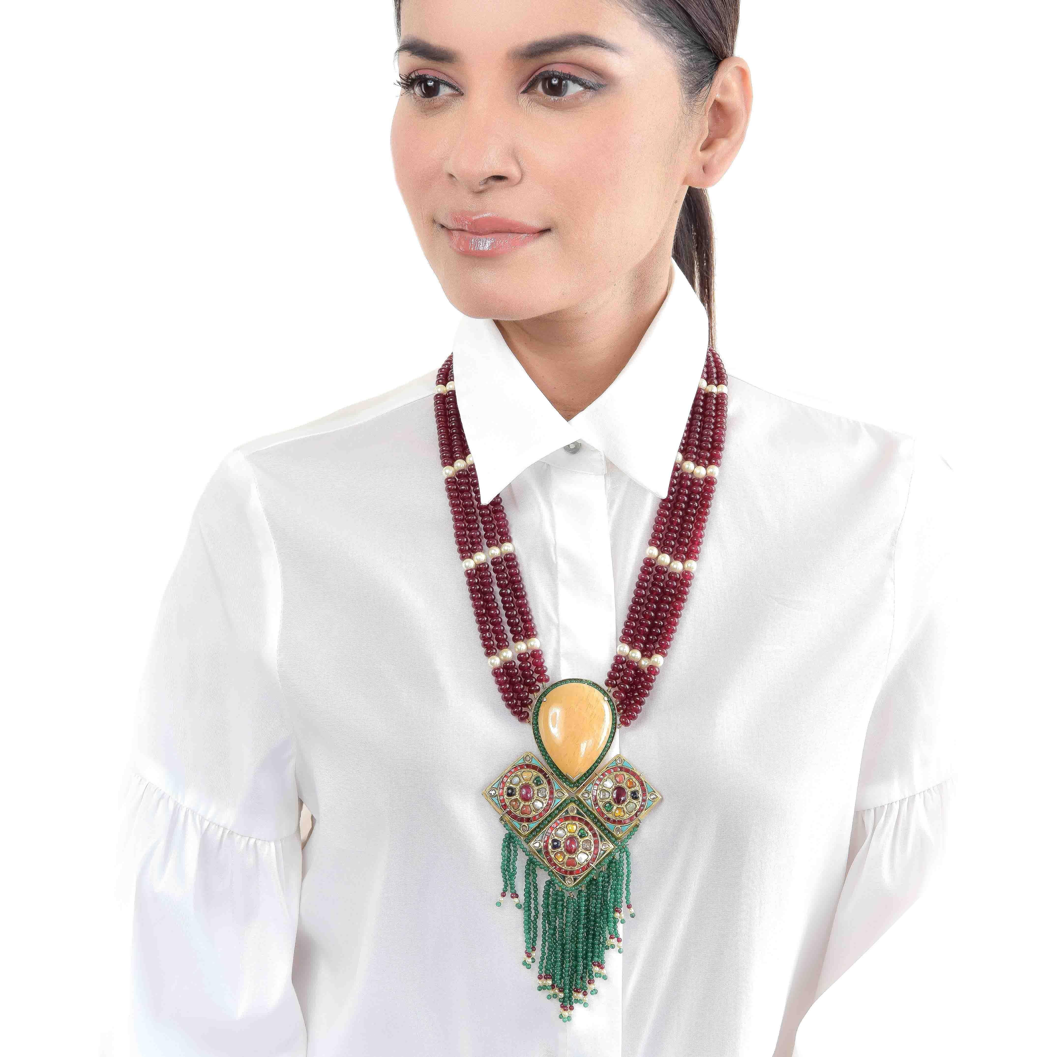 Features bold yellow sapphire and 22k gold square turquoise pieces affixed in a geometric pattern fashioned in ruby and pearl strings with aventurine hangings. Navratan motif in the centrepiece, with the 9 planets of Vedic Astrology, is represented