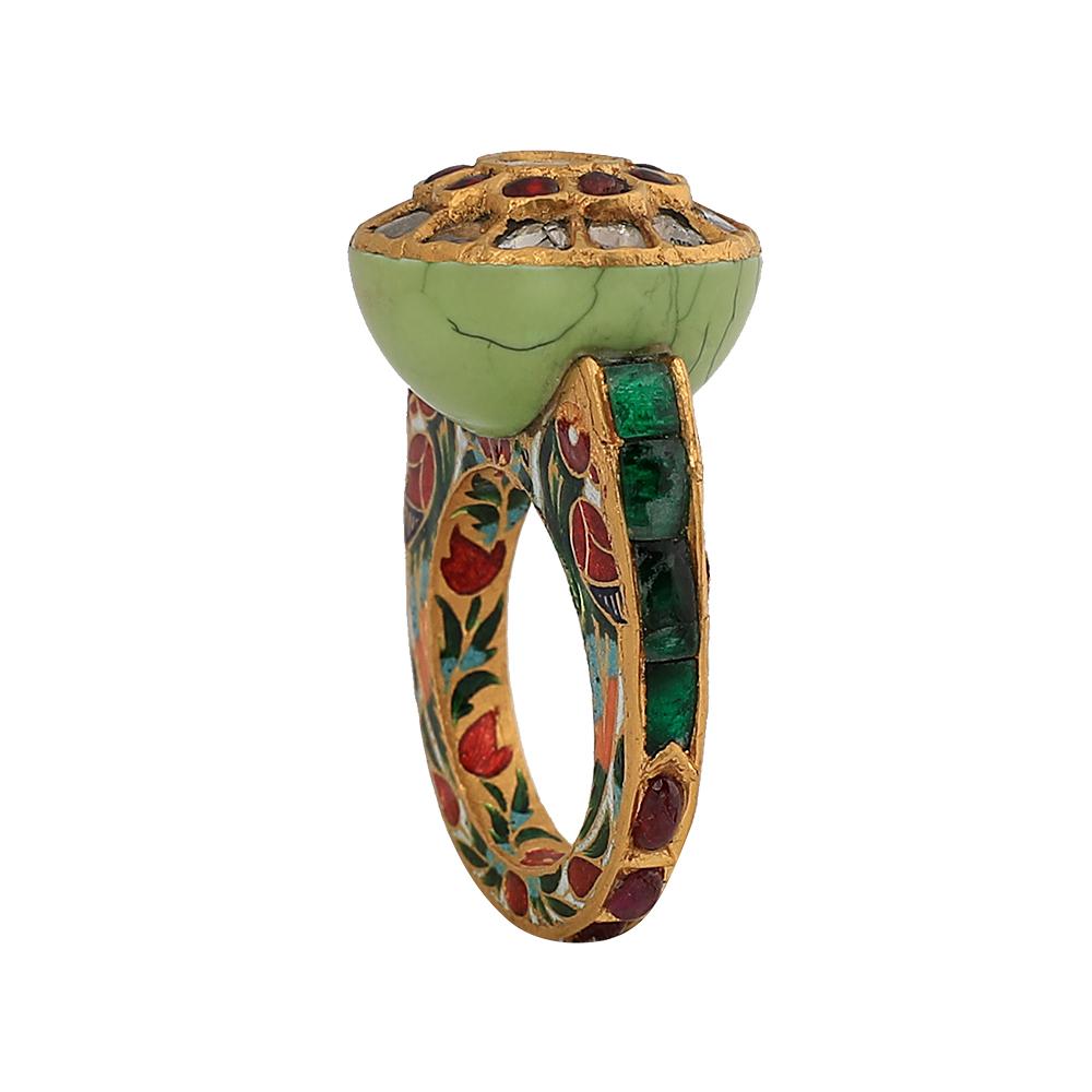 This timelessness yet playful ring is made in 22k gold. Dome comprises beautiful Turquoise fashioned with syndicate polki at centre and rubies around it, with studded emeralds and green, red and gold enamel artwork on the band. This handcrafted work