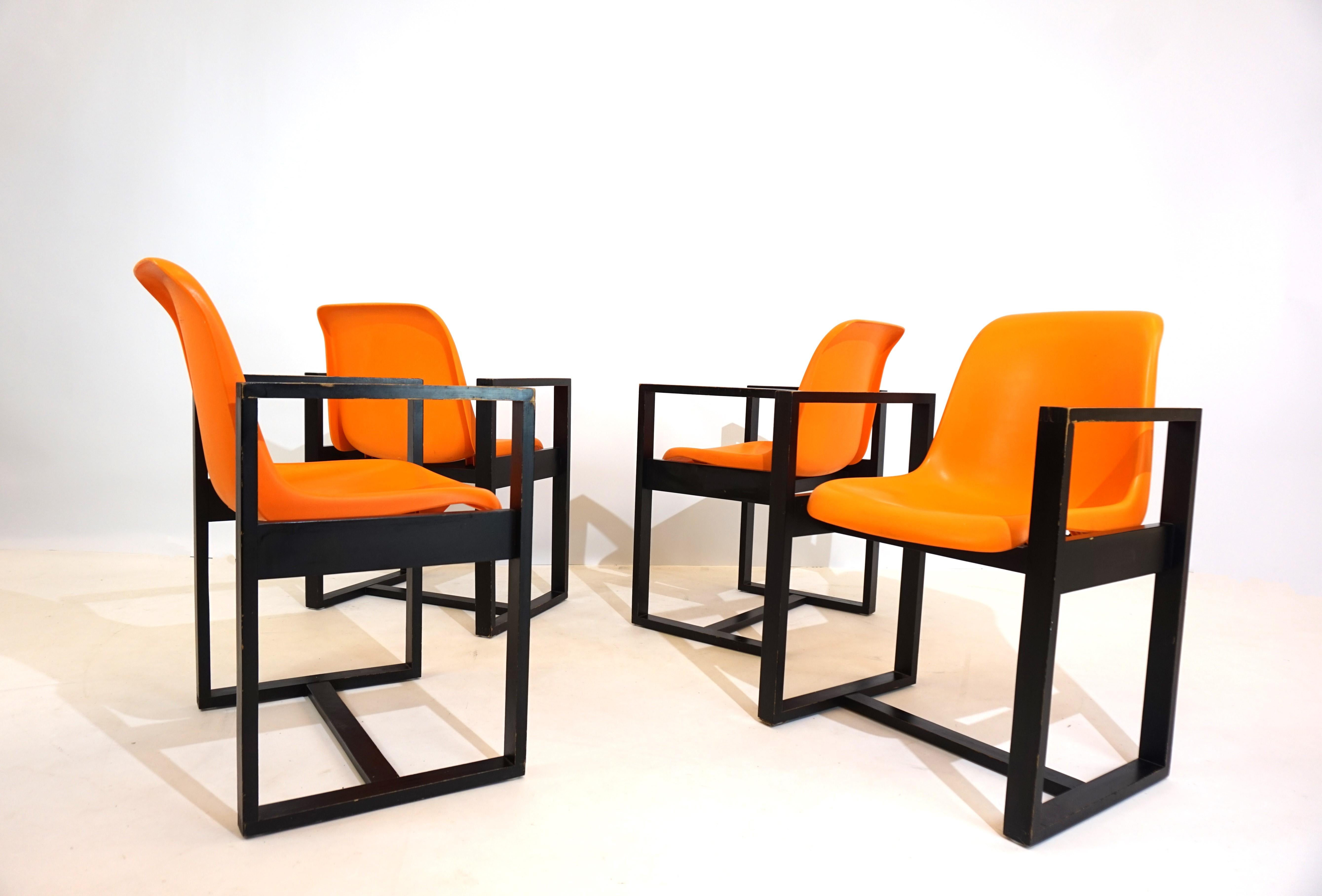 The set of 4 unusual dining/office chairs was designed and produced by mann Möbel in the 1970s. The unusual combination of a wooden frame with a fiberglass shell makes these chairs something special. The seat shells, in the typical orange from 1972,