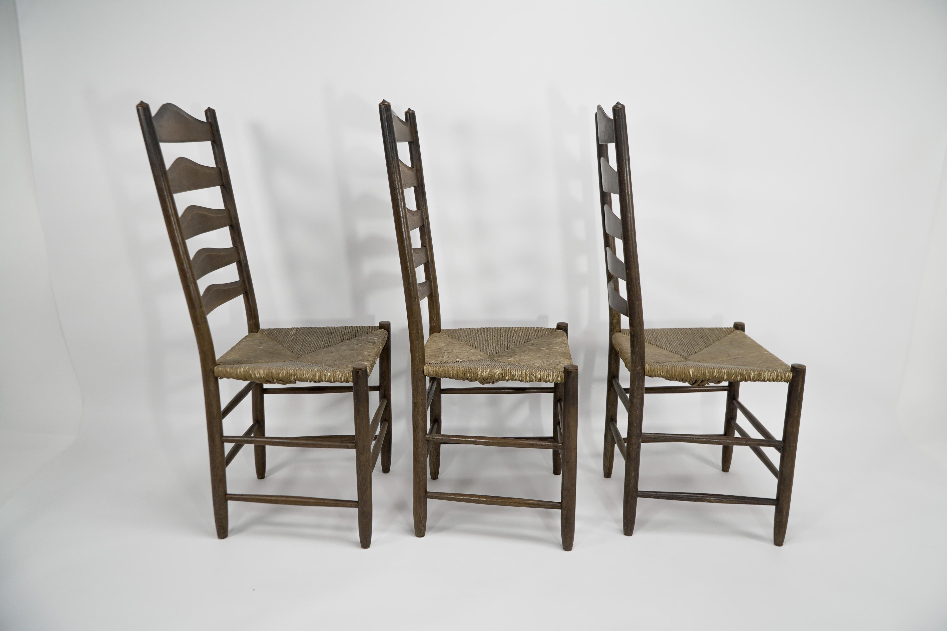 Arts and Crafts À la manière d'E Gimson. Ensemble de trois chaises de salle à manger en chêne de belle qualité avec dossier en échelle. en vente