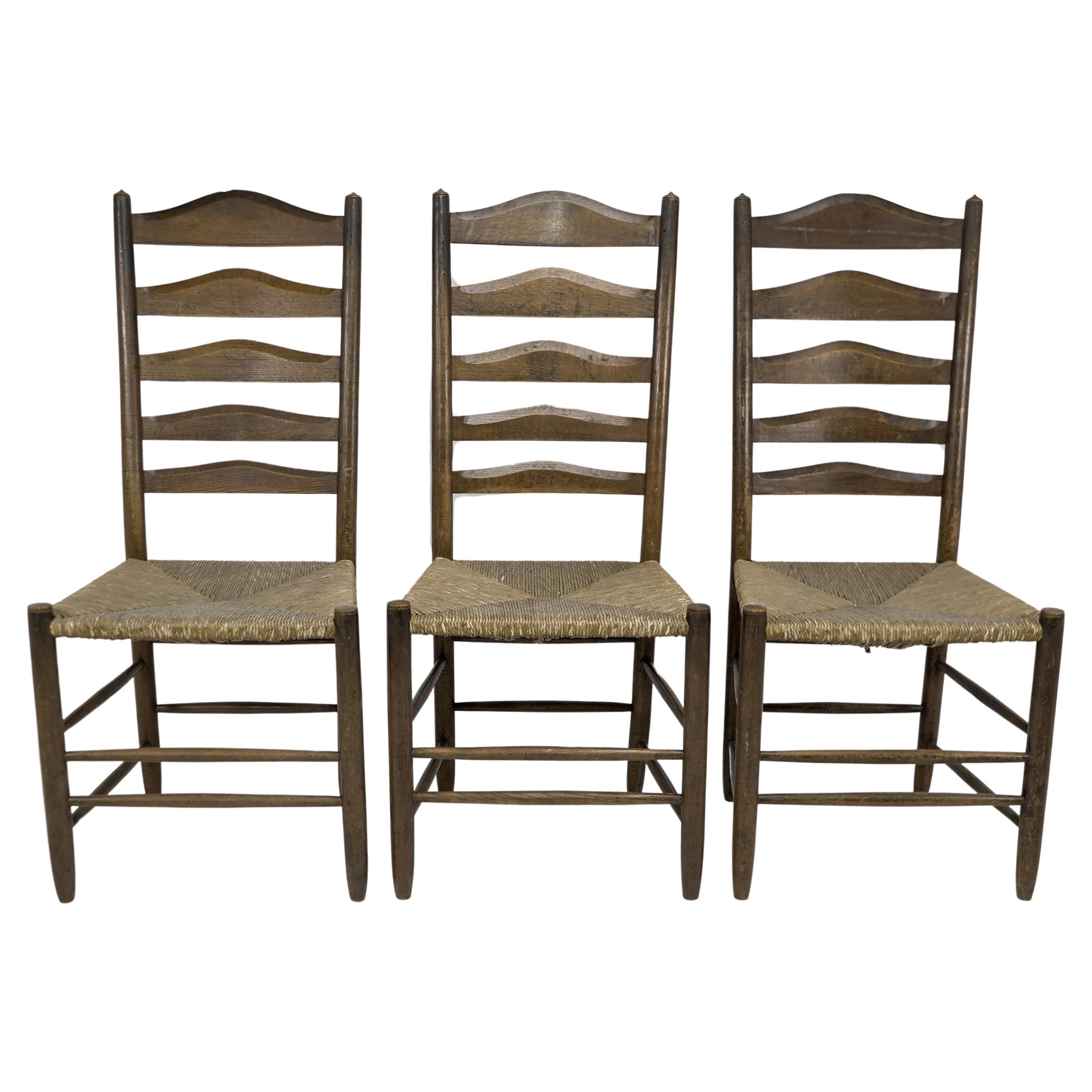À la manière d'E Gimson. Ensemble de trois chaises de salle à manger en chêne de belle qualité avec dossier en échelle. en vente