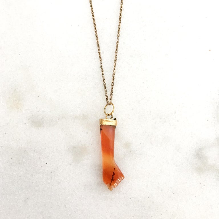 A mano figa amulet charm pendant made of banded orange colored polished agate. Agate has a grounding, stabilizing and protective effect. The agate has some beautiful natural inclusions which are visible to the eye. The figa measures 4.0 centimeters
