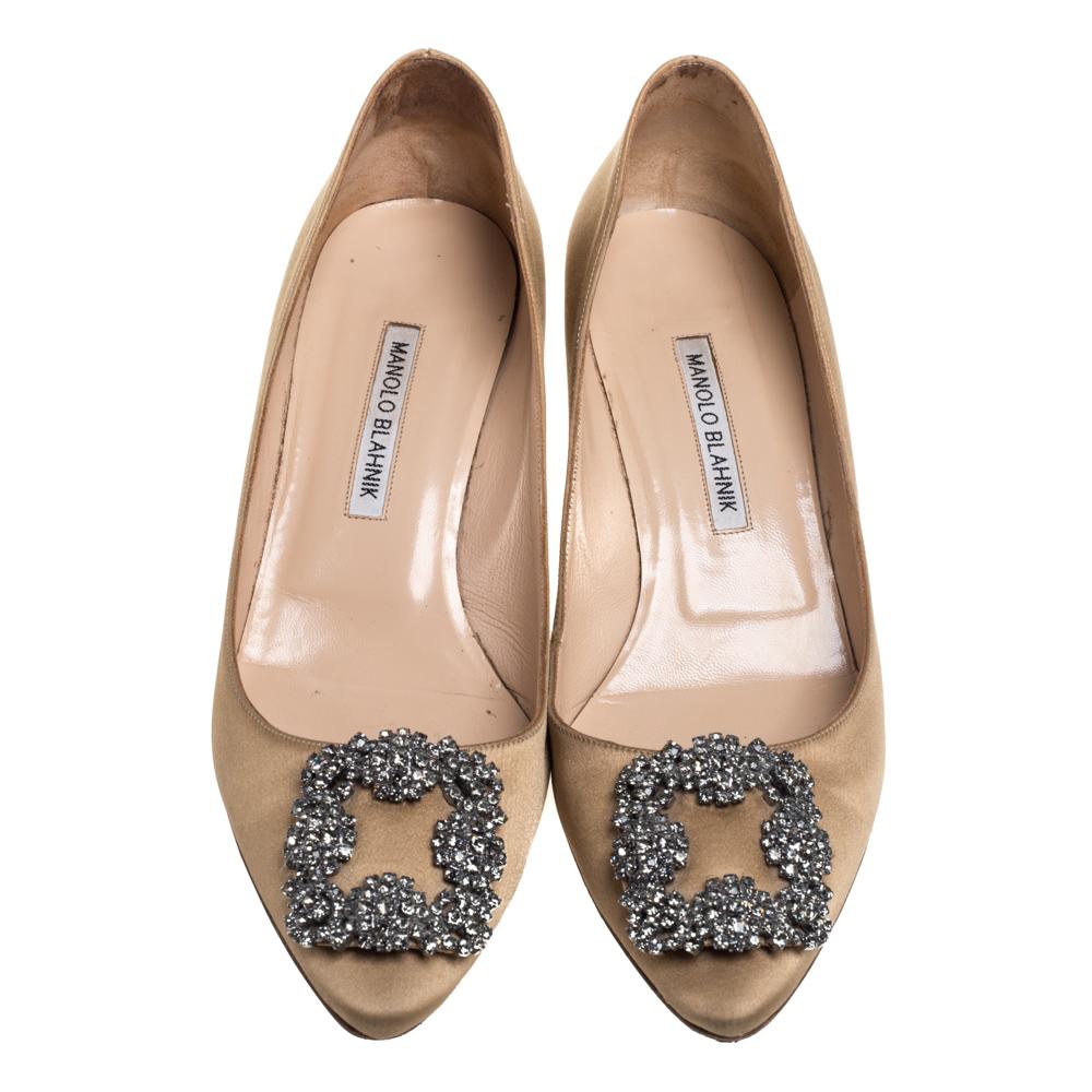 Manolo Blahnik is well-known for his graceful designs, and his label is synonymous with opulence, femininity, and elegance. These iconic Hangisi pumps are crafted from satin in a beige shade into a pointed toe silhouette augmented by the dazzling