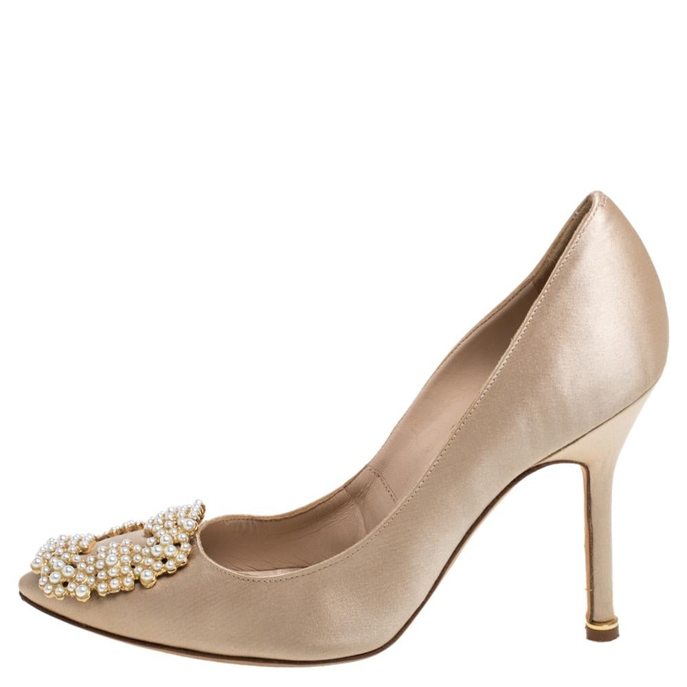 These iconic pumps are by Manolo Blahnik. Styled in beige satin with dazzling pearl embellishments on the toes, and leather insoles to provide comfort, these luxurious pumps will never fail to lift your outfits. Complete with 10 cm heels, you can