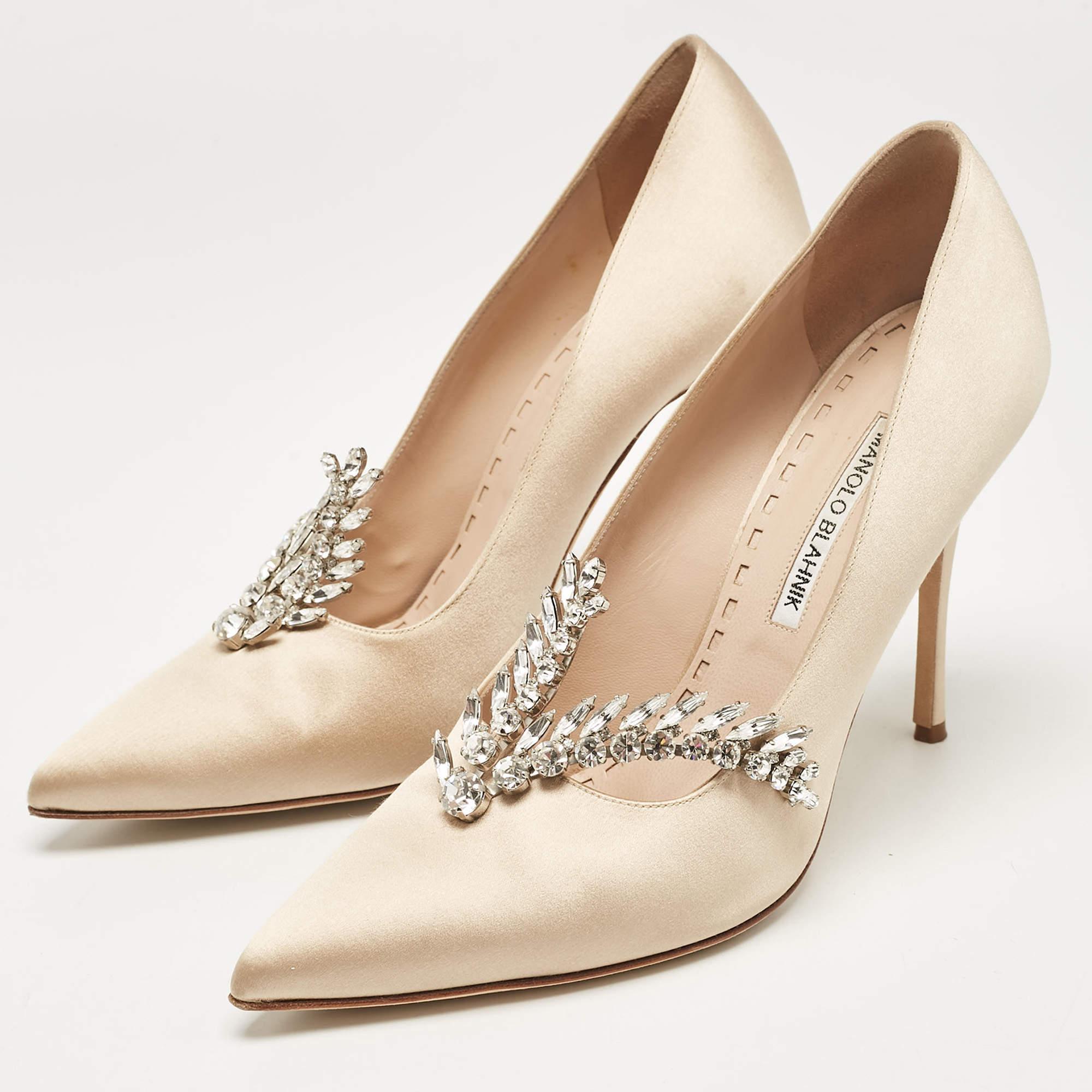 Manolo Blahnik ist bekannt für seine anmutigen Entwürfe und sein Label ist ein Synonym für Opulenz, Weiblichkeit und Eleganz. Diese Nadira Pumps sind aus beigefarbenem Satin in einer spitzen Zehensilhouette gefertigt, die durch schillernde