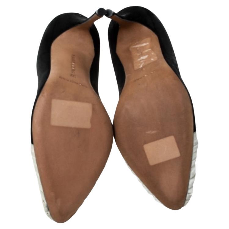 Les escarpins Stunner de Manolo Blahnik présentent une esthétique avant-gardiste. Les escarpins noirs et beiges ont une base en daim et une empeigne ornée de volants. Les volants ressortent et sont surélevés, ressemblant presque à une fleur. Portez