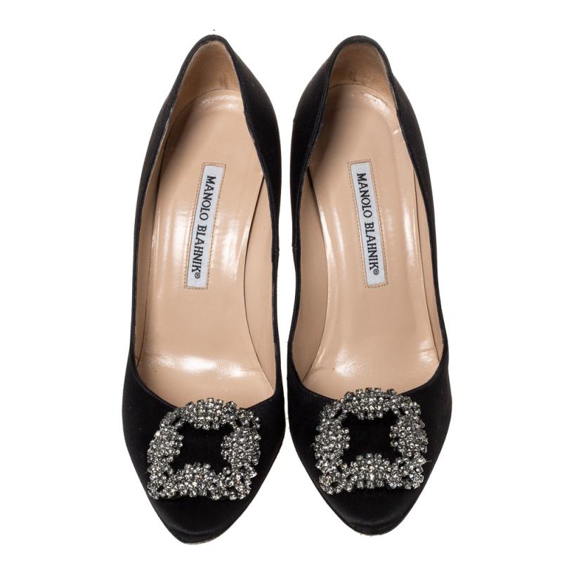 These iconic pumps are by Manolo Blahnik. Styled in black satin with dazzling embellishments on the toes, and leather insoles to provide comfort, these luxurious pumps will never fail to lift your outfits. Complete with 10 cm heels, you can wear
