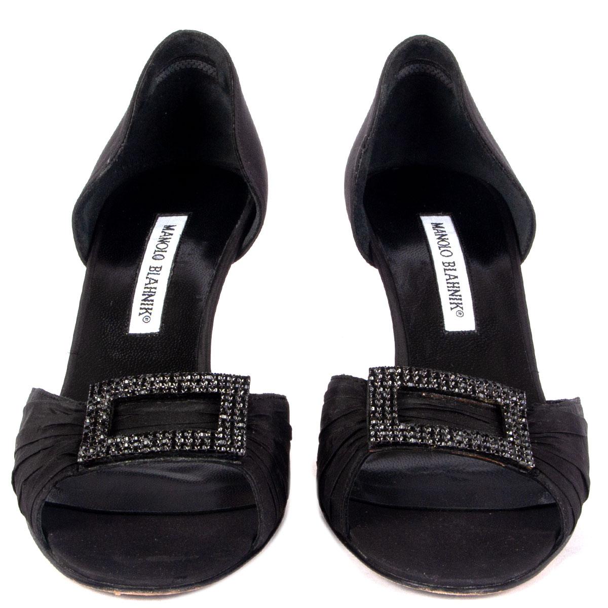 100% authentische Manolo Blahnik Sandalen aus schwarzer Seide, verziert mit Strassschnalle. Sie wurden getragen und sind in einem ausgezeichneten Zustand. 

Messungen
Aufgedruckte Größe	38
Schuhgröße	38
Innensohle	25cm (9.8in)
Breite	7.5cm