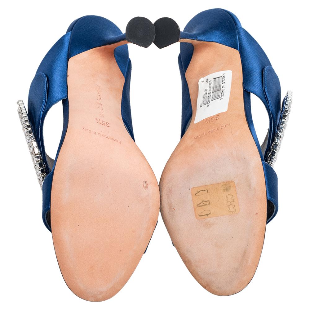 Don't you just wanna grab these mules and try them on? They're beautiful to look at and versatile in design as well. These Manolo Blahnik mules carry satin straps in a shade of blue and buckle details embellished with crystals. This fabulous pair