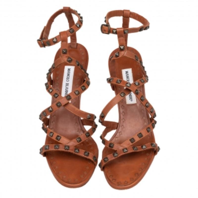 Endless compliments will come your way every time you wear these Manolo Blahnik sandals! The brown sandals are crafted from leather and feature an open-toe silhouette. They have been adorned with stud embellishments and come equipped with ankle