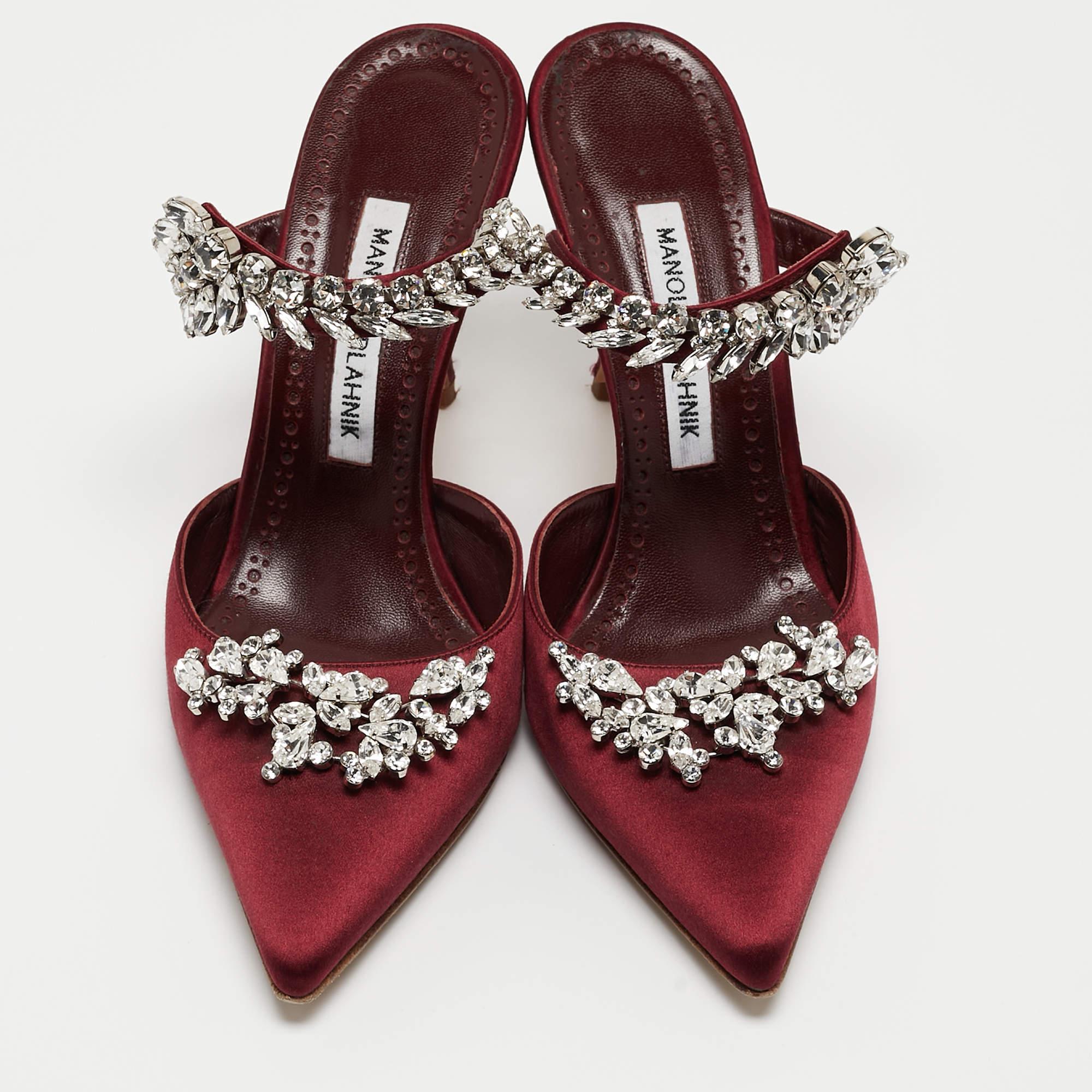 Allow this sumptuous pair of mules by Manolo Blahnik to blow your look. Crafted with satin, they are adorned with eye-catching crystal embellishments and profile adorable pointed toes. The leather-lined insoles carry brand labeling. This pair is