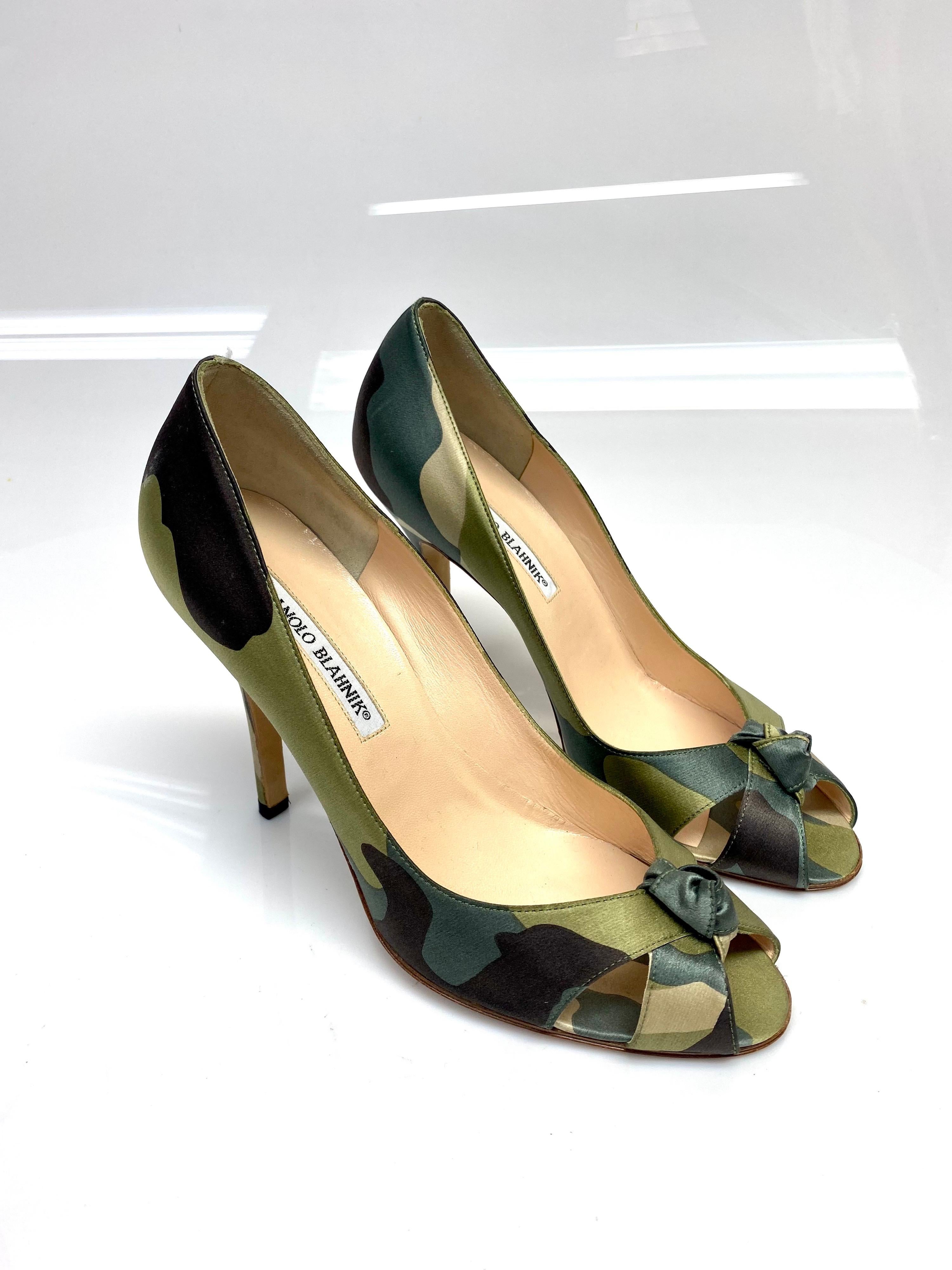 Manolo Blahnik Camouflage Silk Peep Toe Heels Size 38.5. These silk camouflage Manolo Blahnik's are fashions forward with a statement. Featuring a camouflage silk print, peep toe front with a knotted detail. Item is in good condition with some minor
