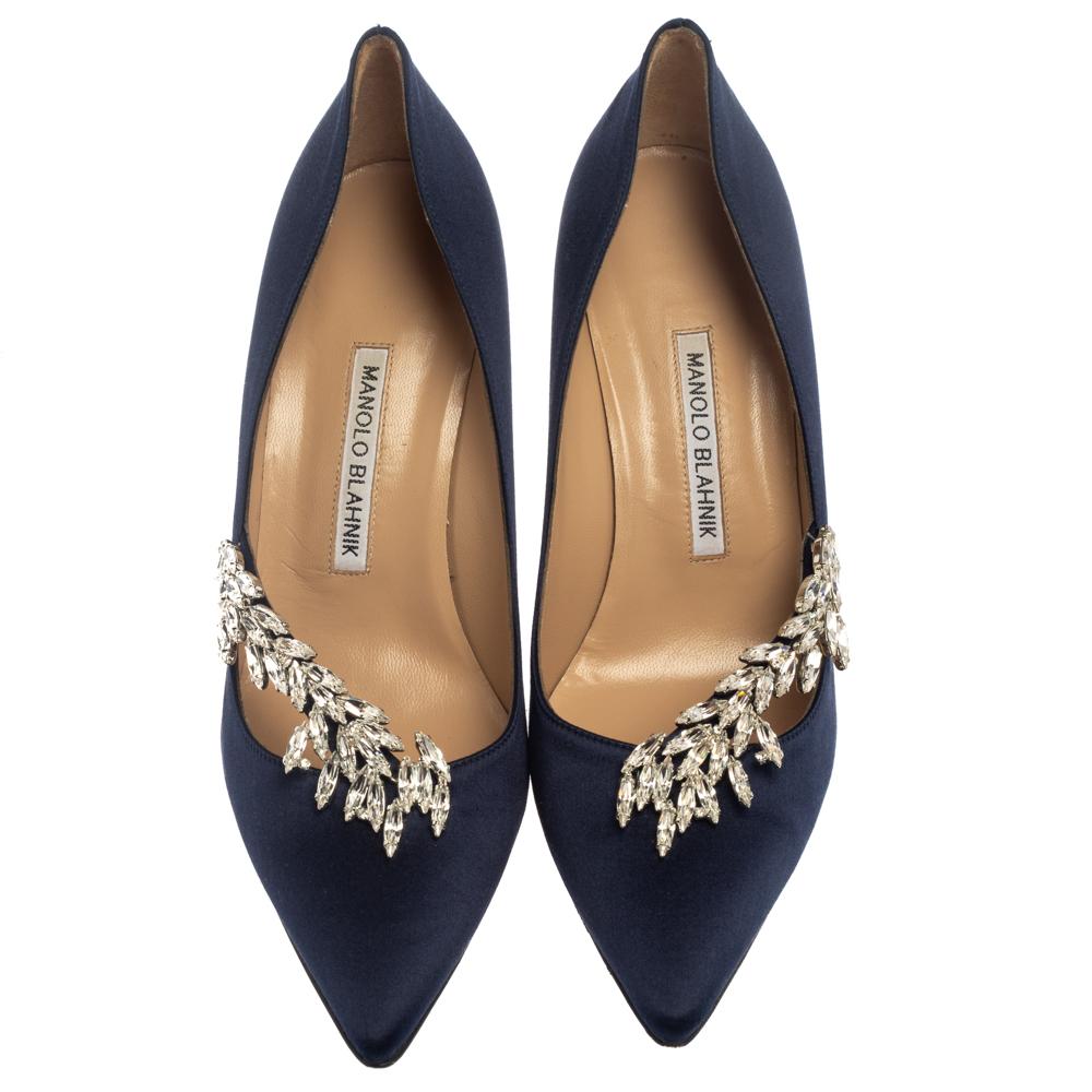 Manolo Blahnik is well-known for his graceful designs, and his label is synonymous with opulence, femininity, and elegance. These Nadira pumps are crafted from satin in a dark blue hue into a pointed toe silhouette augmented by dazzling crystal