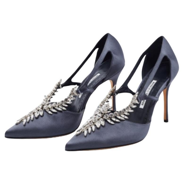To lend your feet elegance, Manolo Blahnik brings you these gorgeous pumps. From their sleek shape and luscious dark grey finish to their overall appeal, they are utterly mesmerizing. The pumps come crafted from smooth satin and are designed with