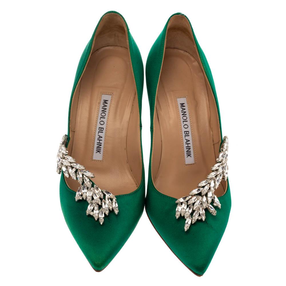 Allow this amazing pair of pumps by Manolo Blahnik to enliven your look. Crafted with emerald green satin, they are adorned with eye-catching Nadira embellishments and profiles adorable pointed toes. The leather-lined insoles carry brand labeling.