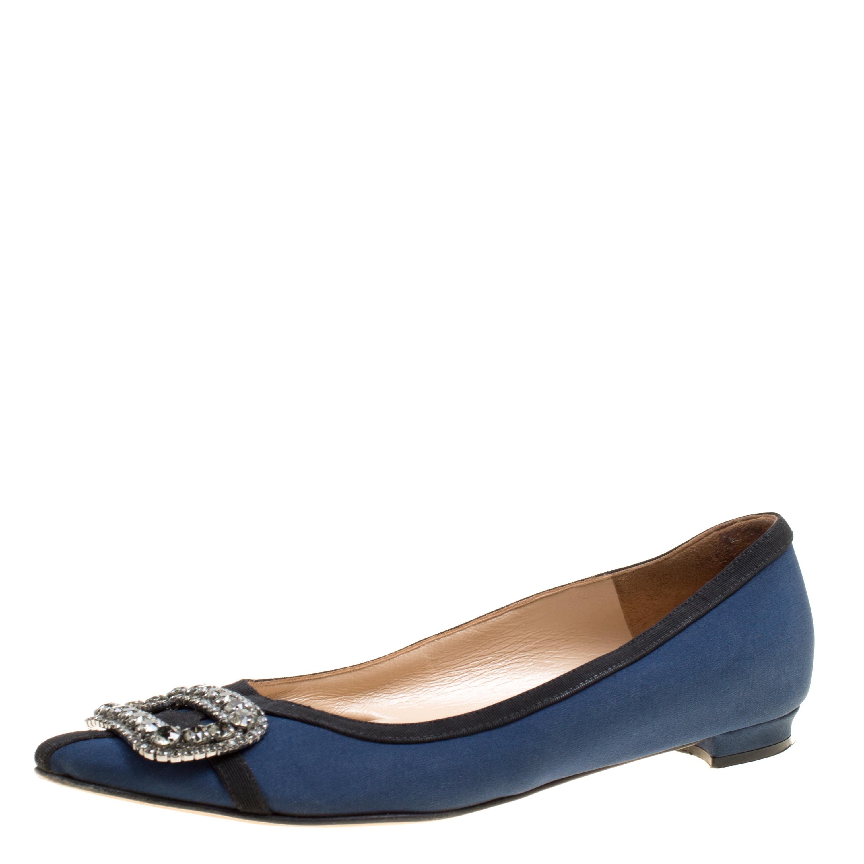 A classic pair of Manolo Blahniks is loved by women all over for its comfort and grace. These pretty shoes are constructed from navy blue satin fabric and it further made special with a buckle style crystal embellished design at the front which is