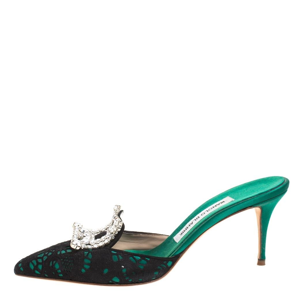 These Manolo Blahnik mules are crafted from green suede layered with black satin on the vamps with pointed toes. The signature square buckles are embellished with Borli crystals. The stiletto heels add style to the delicate design. This slip-on pair