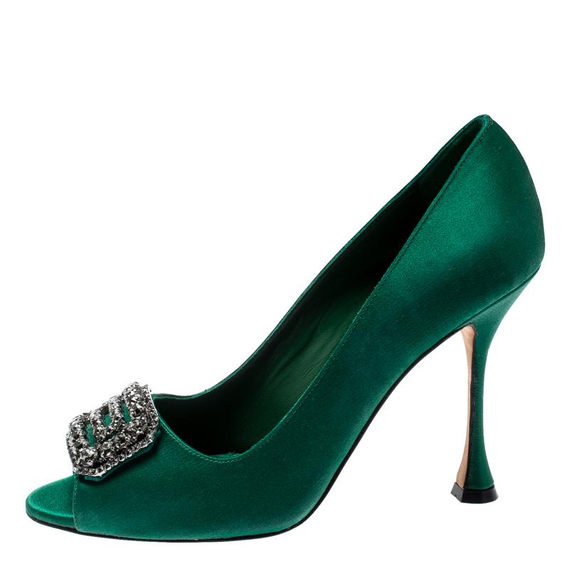 Walk with grace and confidence in these green pumps by Manolo Blahnik. Flaunting contemporary fashion with peep toes which are enhanced with a gunmetal-tone, crystal embellished brooch at the vamps, leather lining, comfortable insole and 10 cm