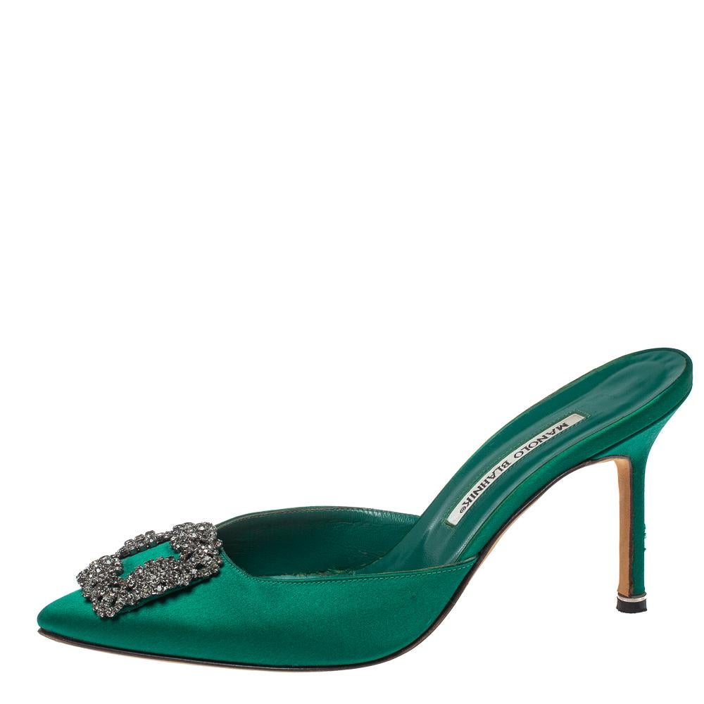 Manolo Blahnik is synonymous with opulence, femininity, and elegance, and his creations are a reflection of that. These Hangisi mules are crafted from satin in a green shade into a pointed toe silhouette augmented by the dazzling buckle perched on