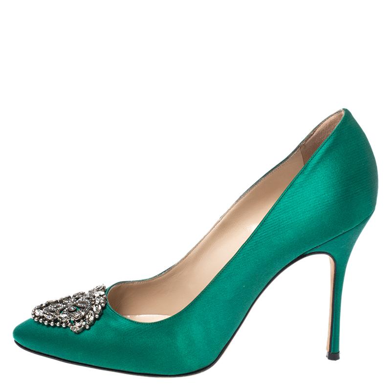 Add grace and elegance to your outfit with these stylish pumps from Manolo Blahnik. The shoes have a stunning emerald green body with an almond toe design. The top features a silver-toned metal and crystal ornament which elevates the look of the