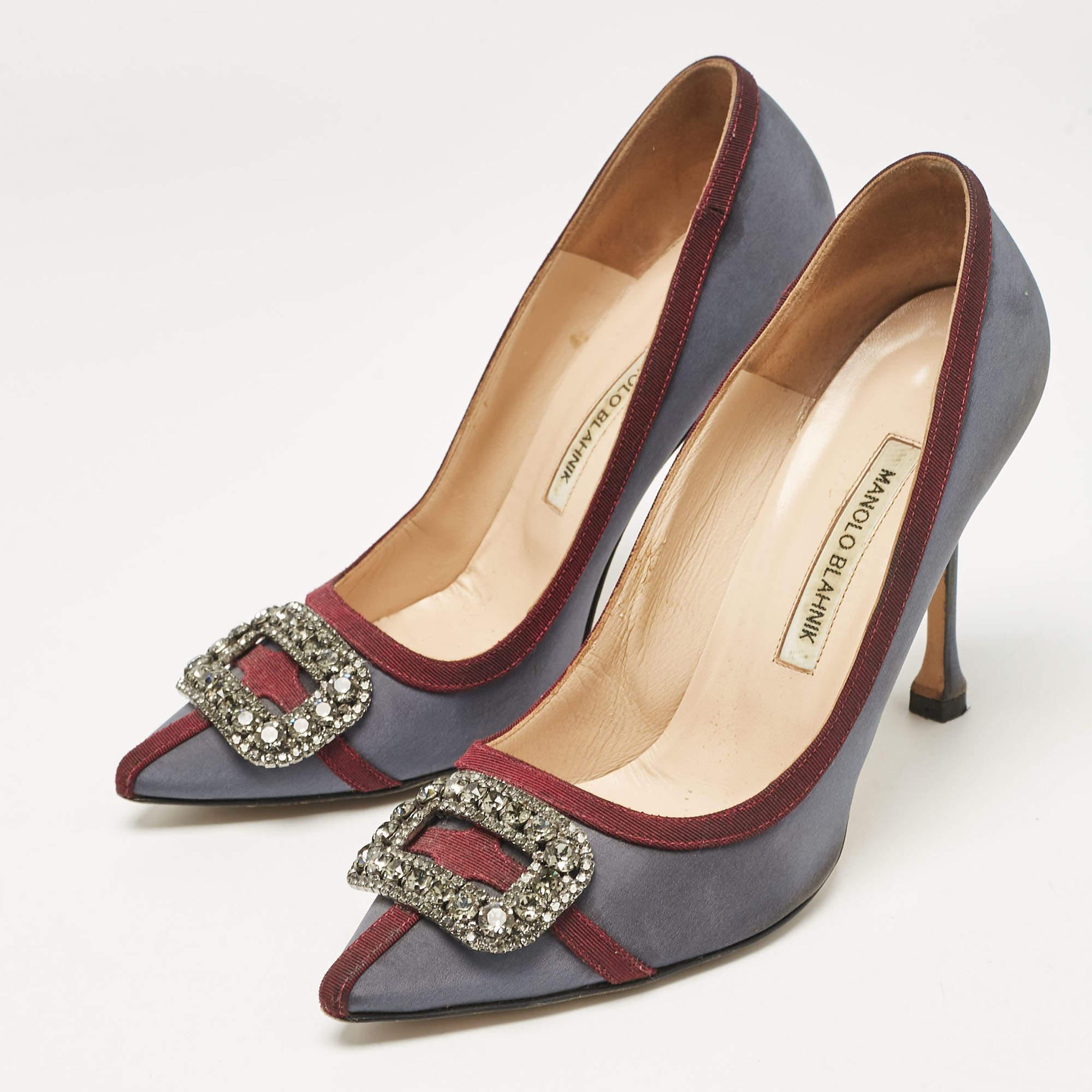 Walk with grace and confidence in these Gotrian pumps by Manolo Blahnik. Styled with classic grey and burgundy hues with dazzling crystal embellishments on the pointed toes and leather insoles to provide comfort  these satin pumps will never fail to