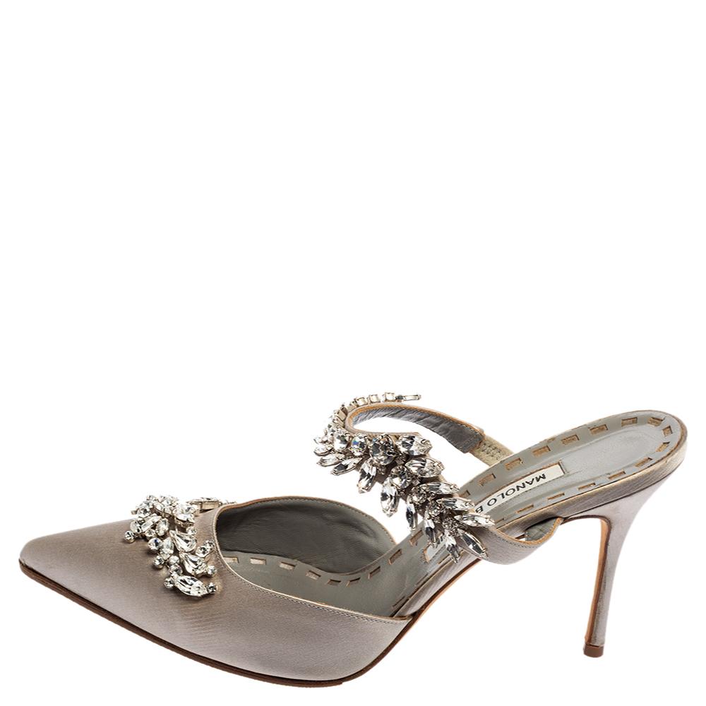 Allow this sumptuous grey pair of pumps by Manolo Blahnik to blow your look. Crafted with satin, they are adorned with eye-catching crystal embellishments and profiles adorable pointed toes. The leather-lined insoles carry brand labelling. This pair