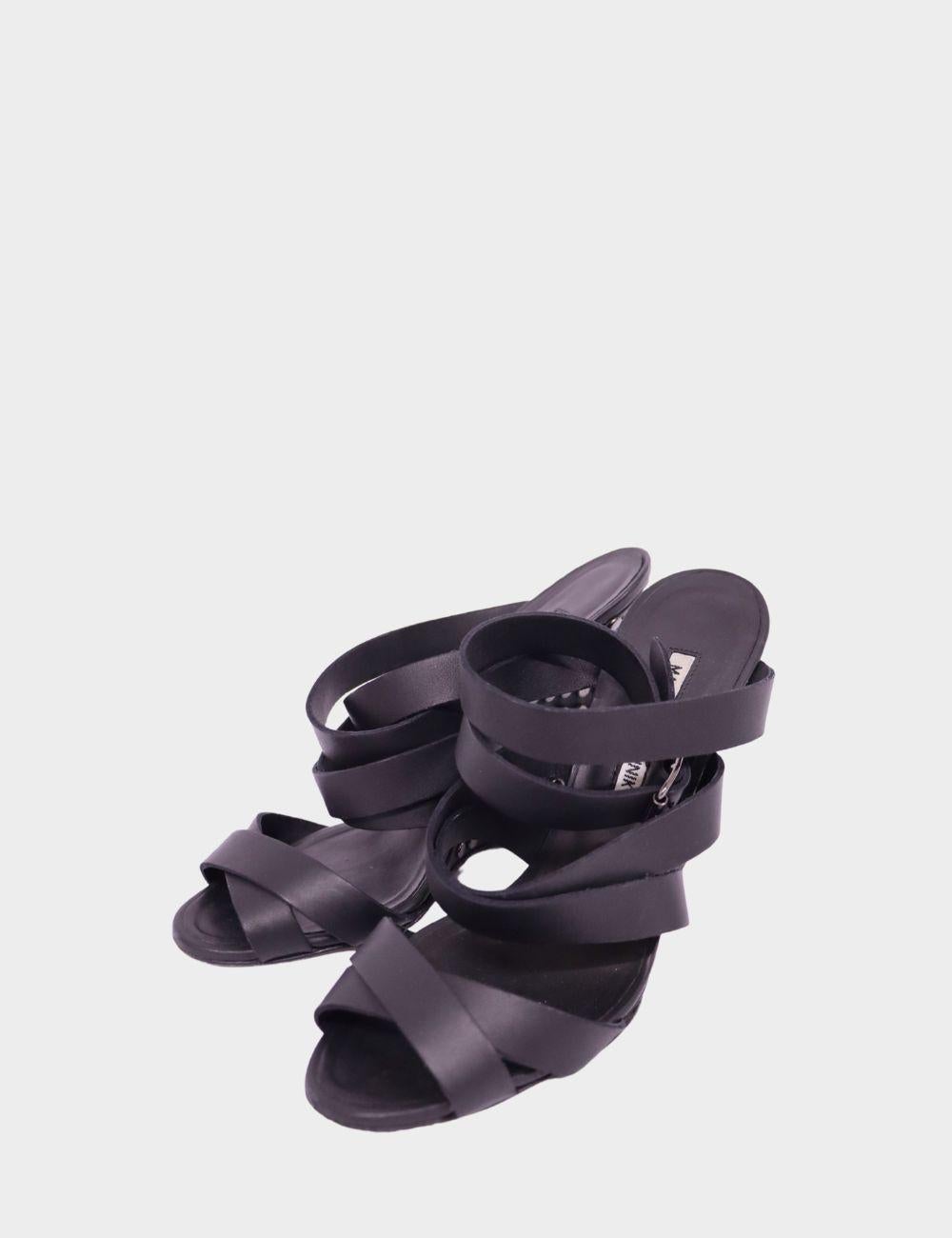 Elevate your evening style with these sophisticated Manolo Blahnik black satin strappy sandals. Featuring an elegant open-toe design with crossover straps and a secure ankle wrap, these heels are the epitome of refined glamour. Perfect for weddings,