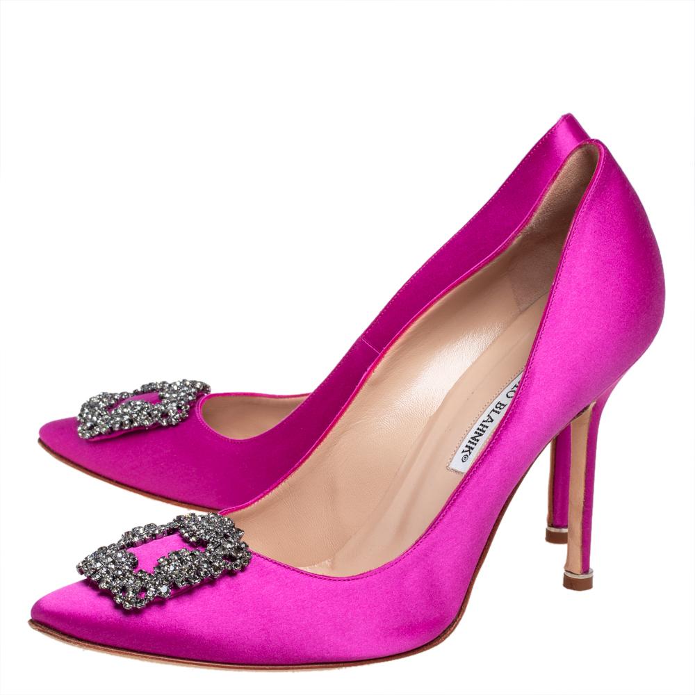 These iconic pumps are by Manolo Blahnik. Styled with dazzling embellishments on the toes, and leather insoles to provide comfort, these luxurious pumps in magenta satin will never fail to lift your outfits. Complete with 11 cm heels, you can wear