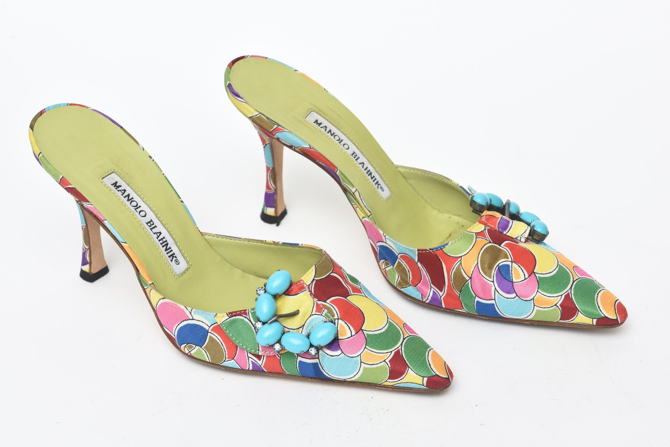 This gorgeous pair of Manolo Blahnik pair of sexy mules have the most luscious silk printed design on them with chartreuse leather interior. The design is very Pucci esque. The turquoise like stones in a half moon cluster on the side add dimension