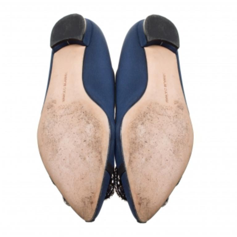 Une paire classique de Manolo Blahniks est appréciée par les femmes du monde entier pour son confort et sa grâce. Ces jolies chaussures sont fabriquées en satin bleu marine et sont rehaussées d'une boucle ornée de cristaux à l'avant, unique et