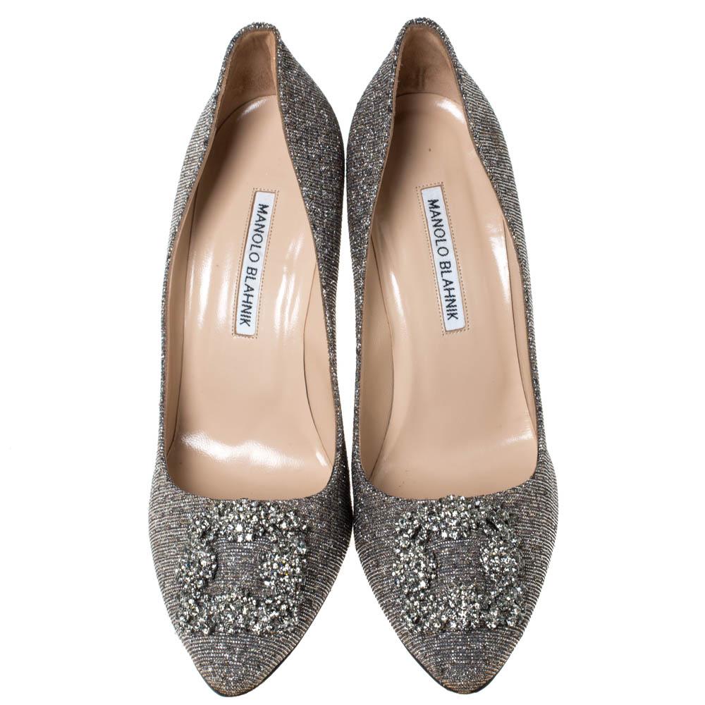 Walk with grace and confidence in these pumps by Manolo Blahnik. Styled in silver, with dazzling crystal embellishments on the toes, and leather insoles to provide comfort, these glitter fabric Hangisi pumps will never fail to lift your outfits.