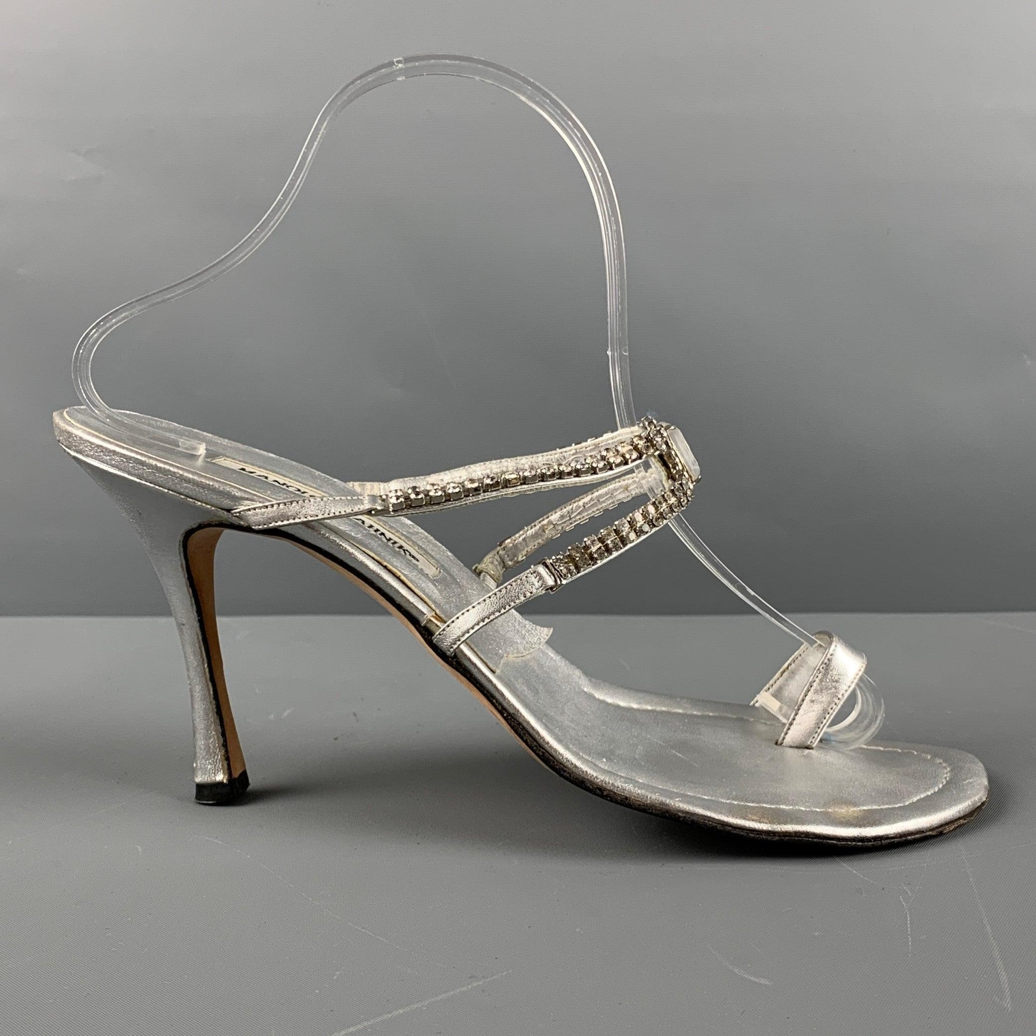 MANOLO BLAHNIK sandals comes in a silver leather featuring a ring toe, buckle rhinestone detail and a stiletto heel. Made in Italy.Good Pre-Owned Condition. AS IS. 

Marked:   40 1/2 

Measurements: 
  Heel: 4 inches  
  
  
 
Sui Generis