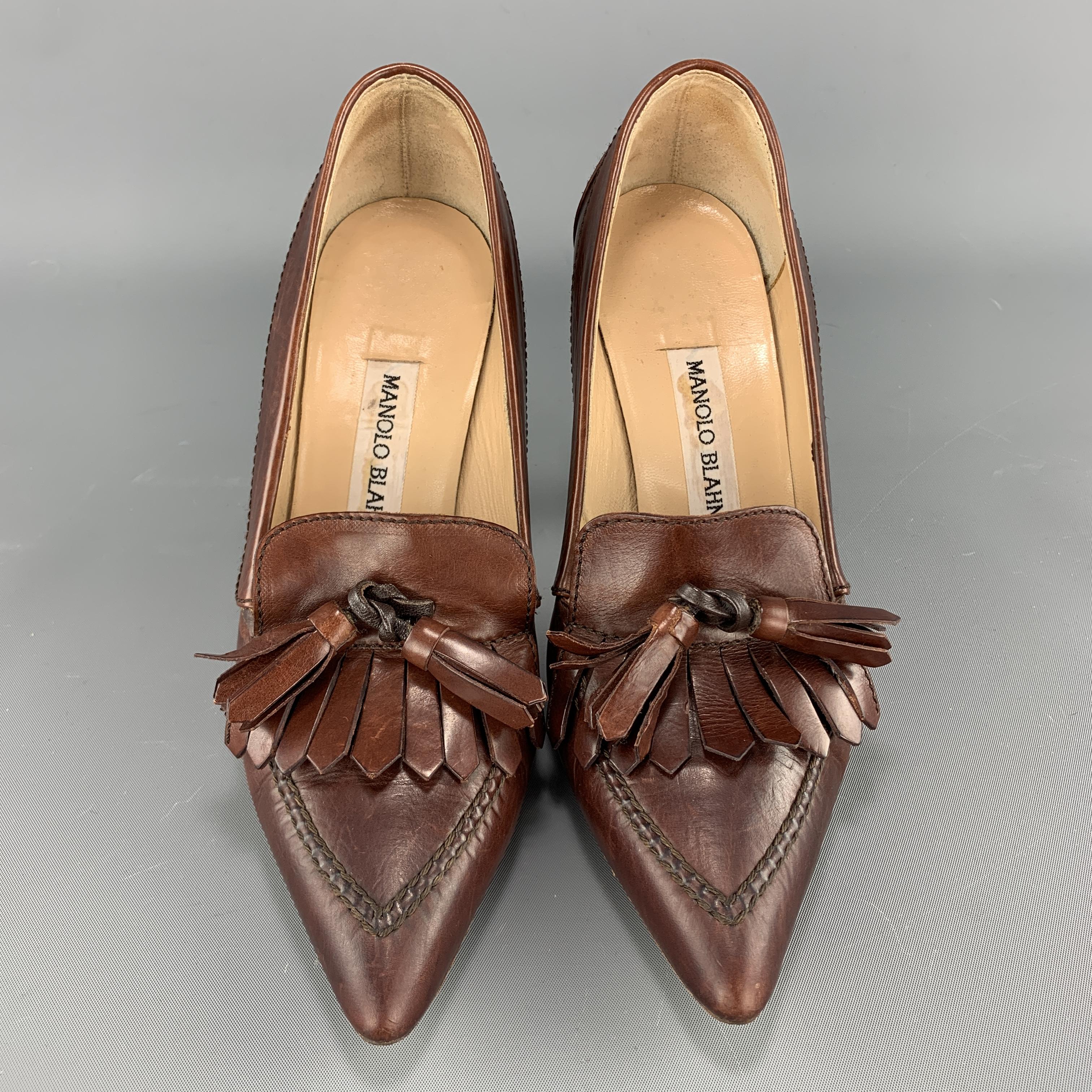 MANOLO BLAHNIK pumps come in tan brown leather with a pointed apron toe, detailed with eyelash fringe and tassels. Made in Italy.

Very Good Pre-Owned Condition.
Marked: IT 35.5

Heel: 4 in.